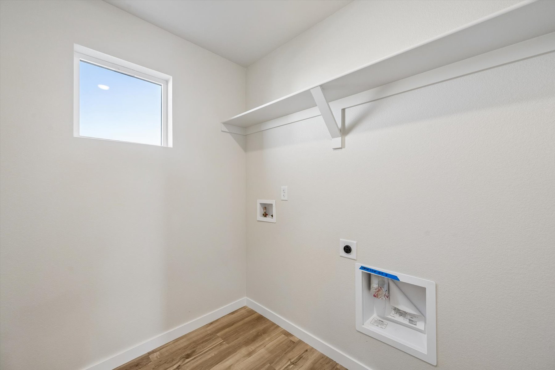 A room with a wood floor and a window.