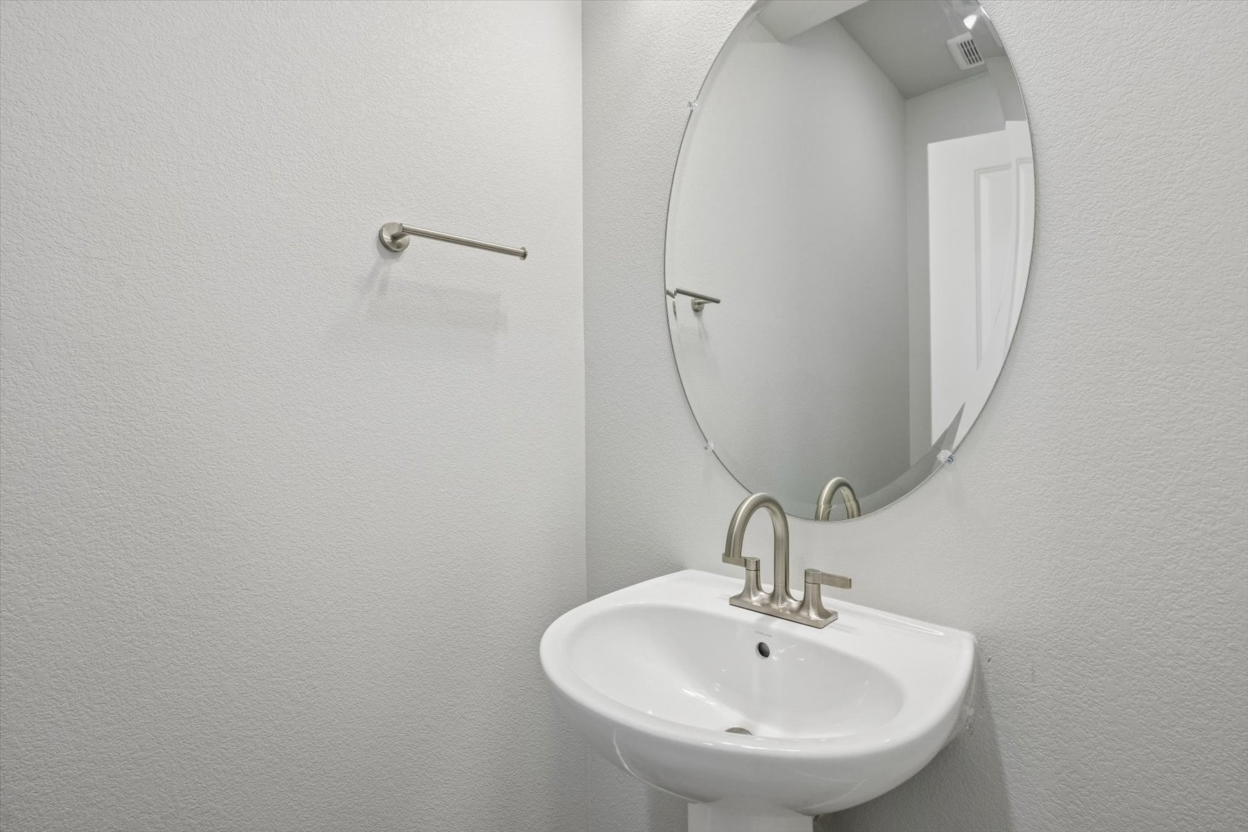 A bathroom with a round mirror.