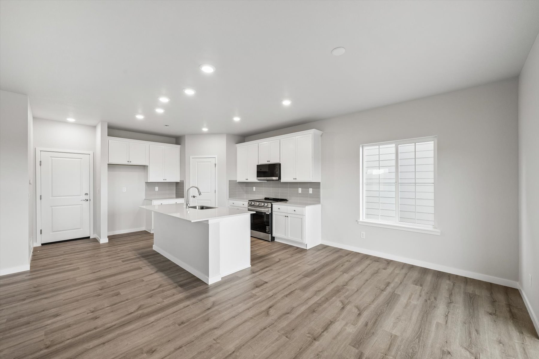 A kitchen with white cabinets.