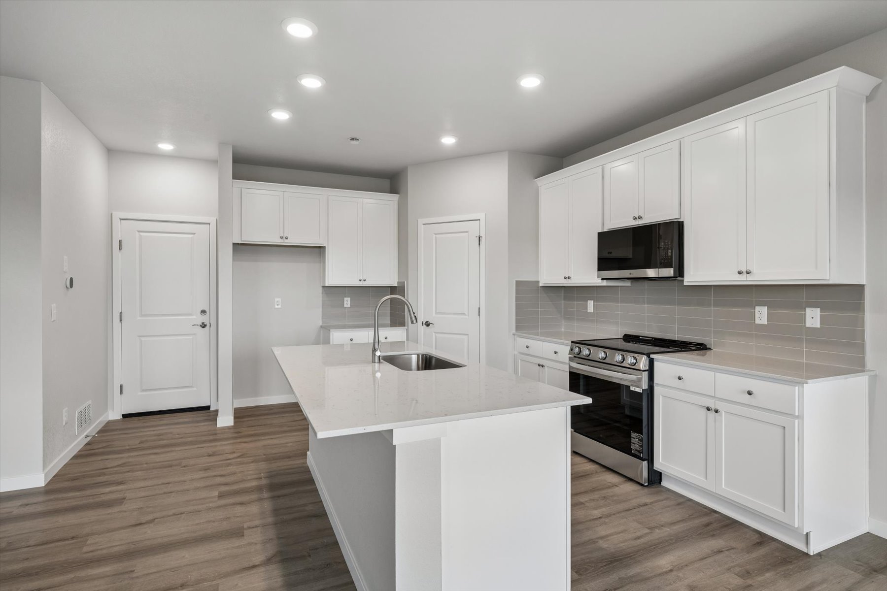 A kitchen with white cabinets.