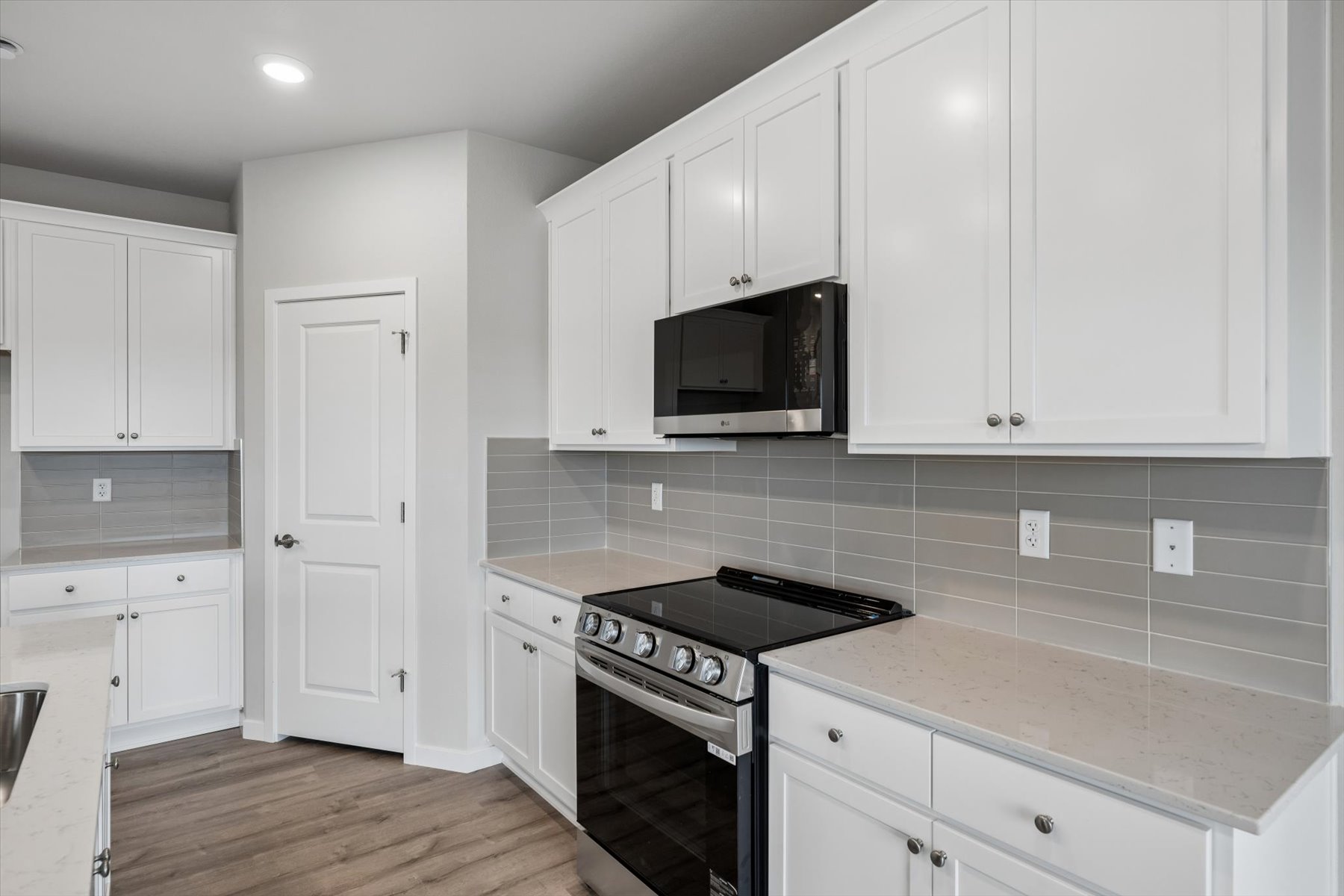 A kitchen with white cabinets.