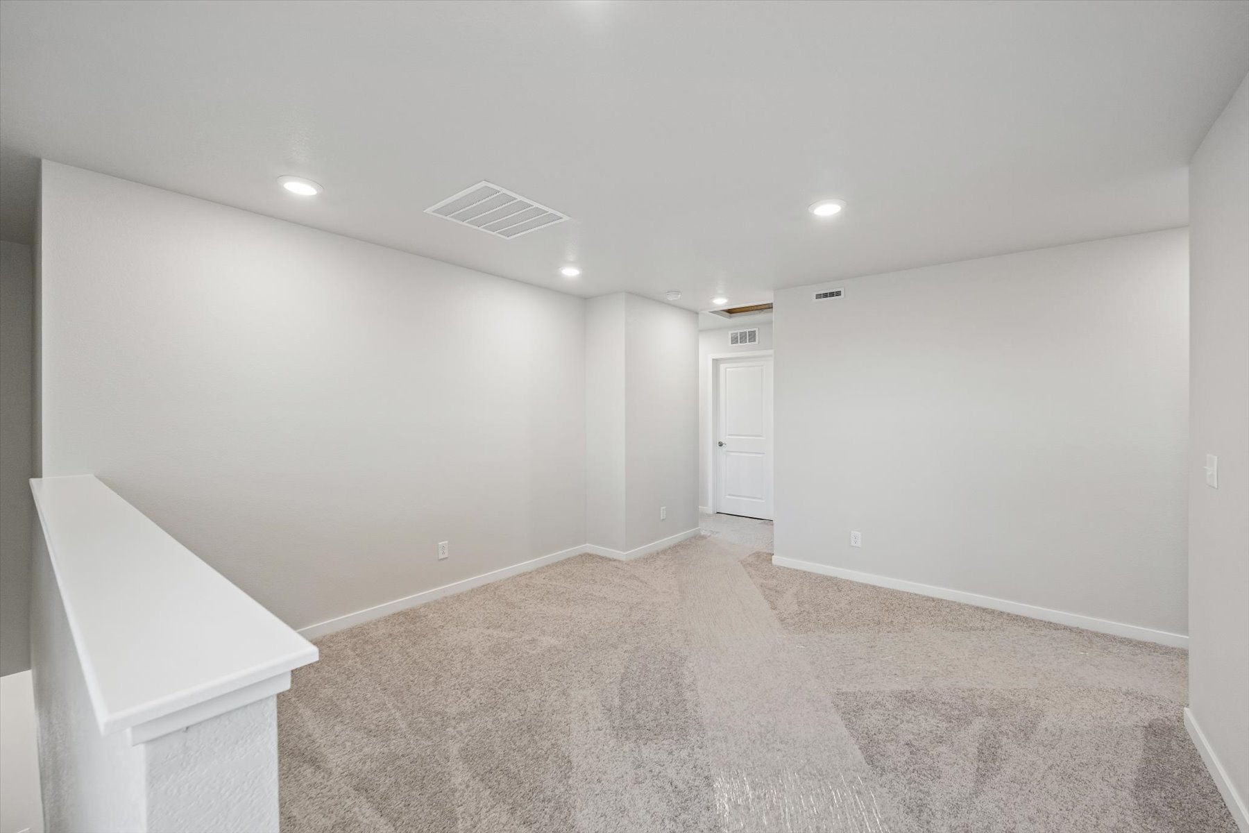 A room with a white wall and a white table.