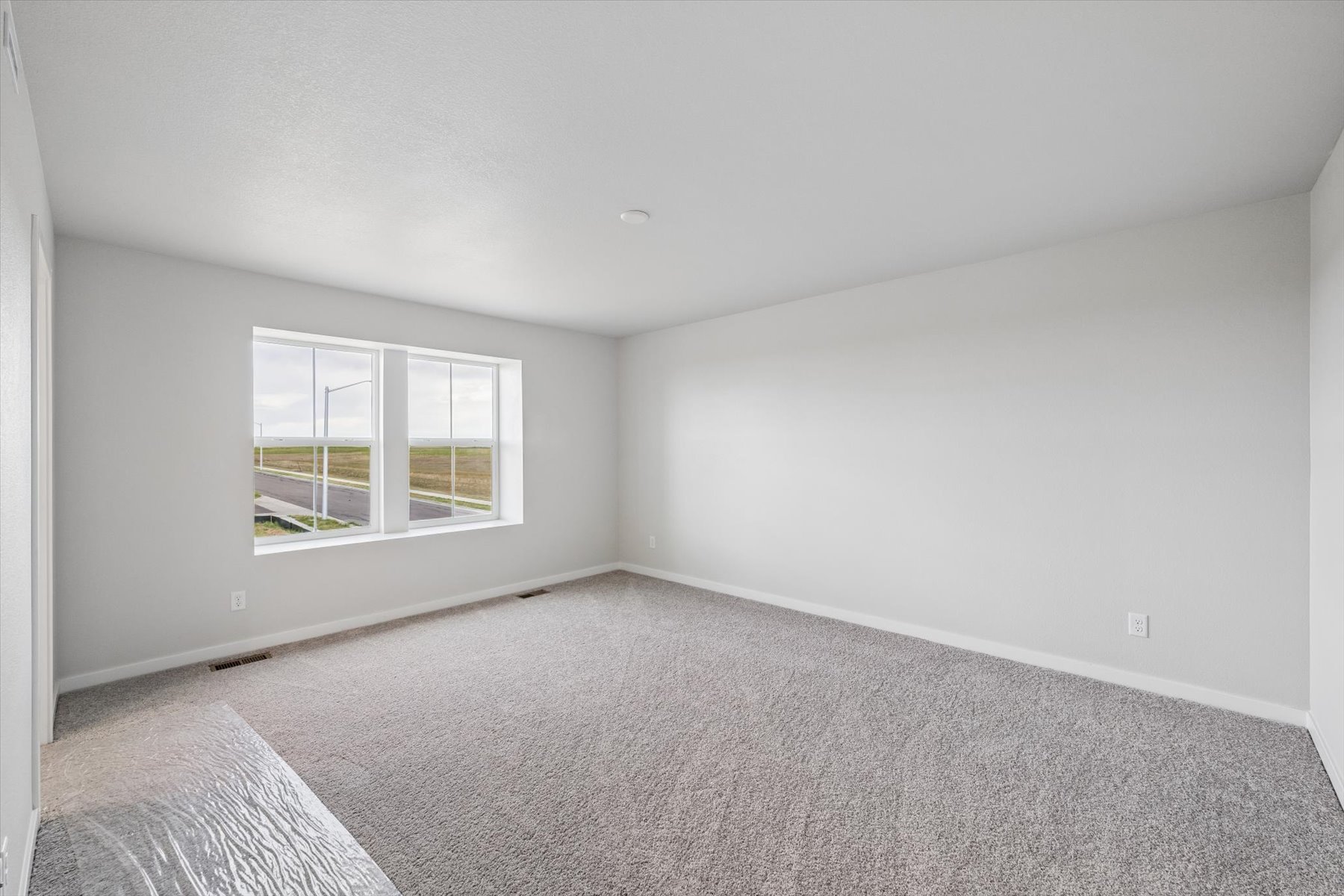 A room with a carpet and a window.