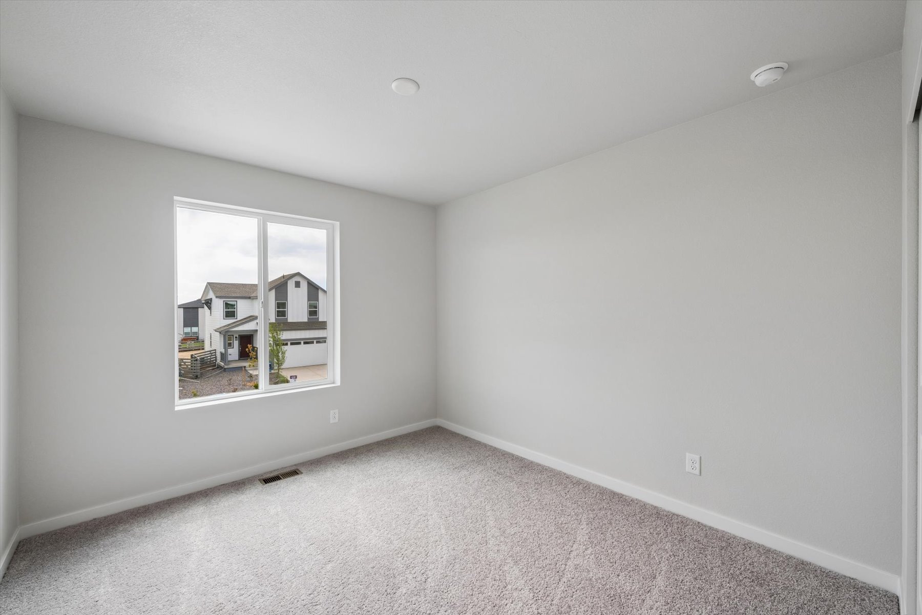 A room with a window and a carpet.