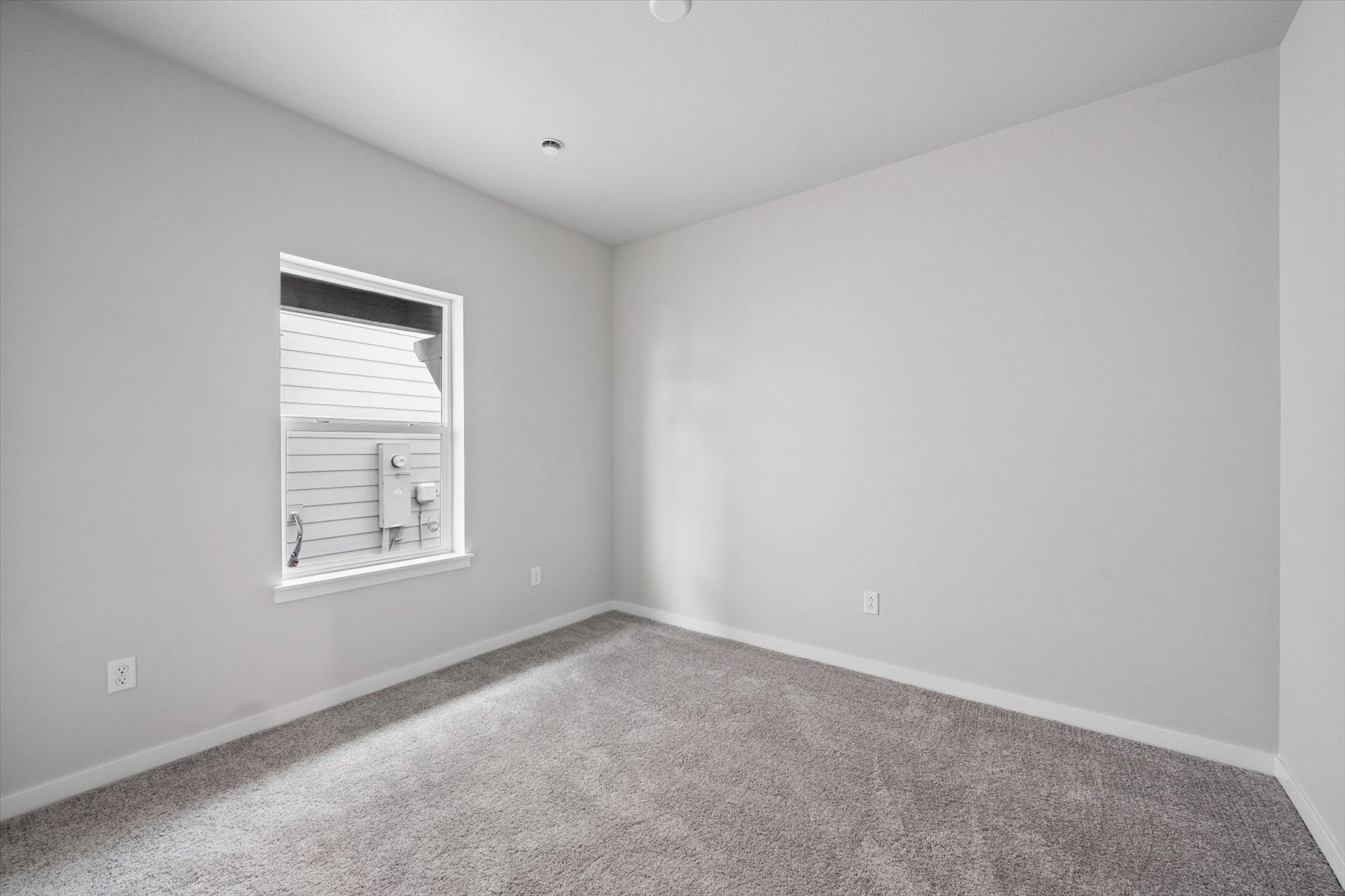 A room with a window and carpet.