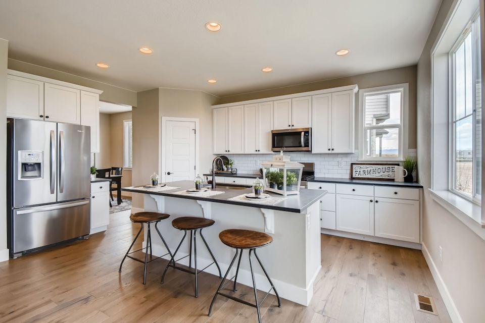 A kitchen with white cabinets.
