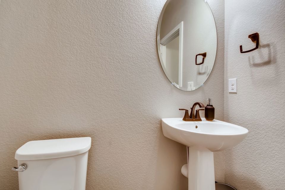 A bathroom with a round mirror.