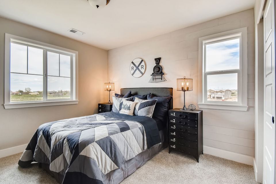 A bedroom with a bed and lamps.