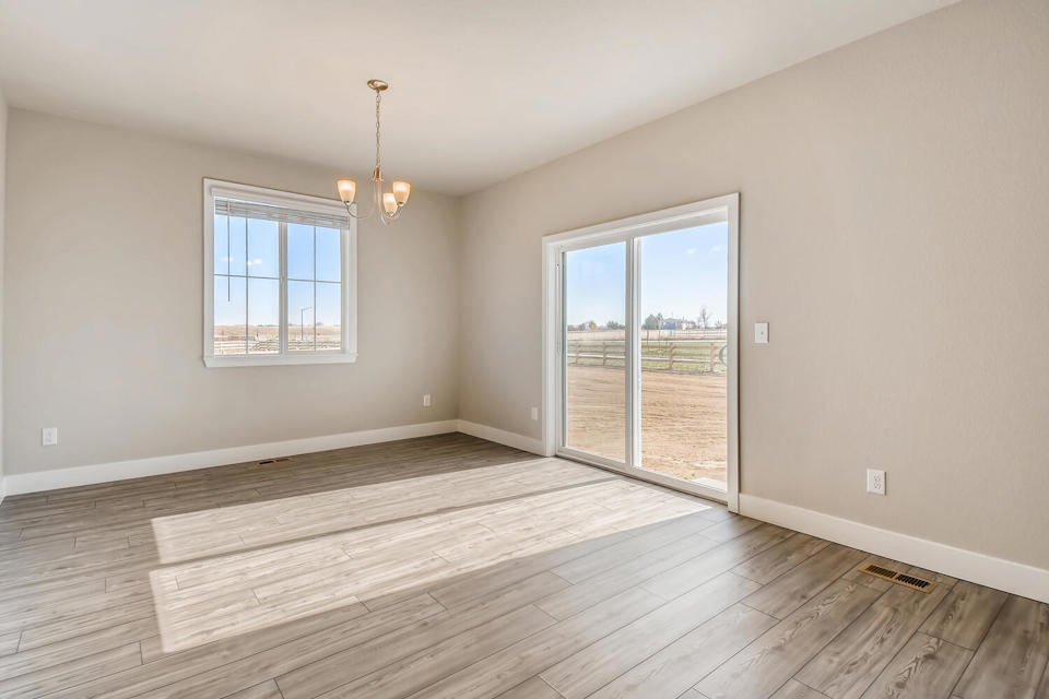 A room with a wood floor and a wood floor with a window.