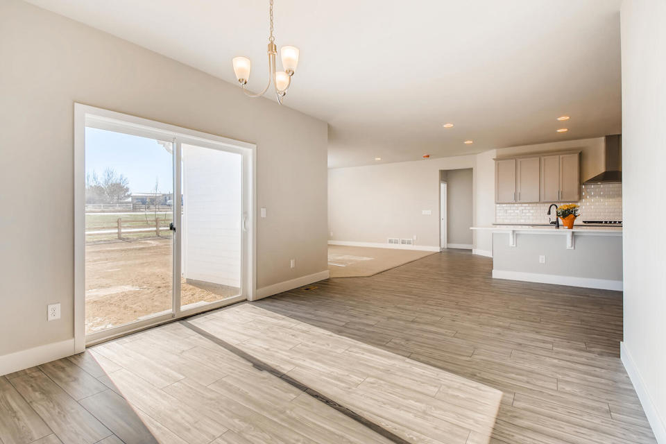 A room with a wood floor and a glass door.