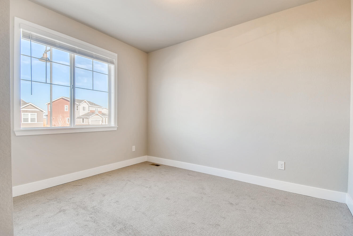 A room with a window and a carpet.