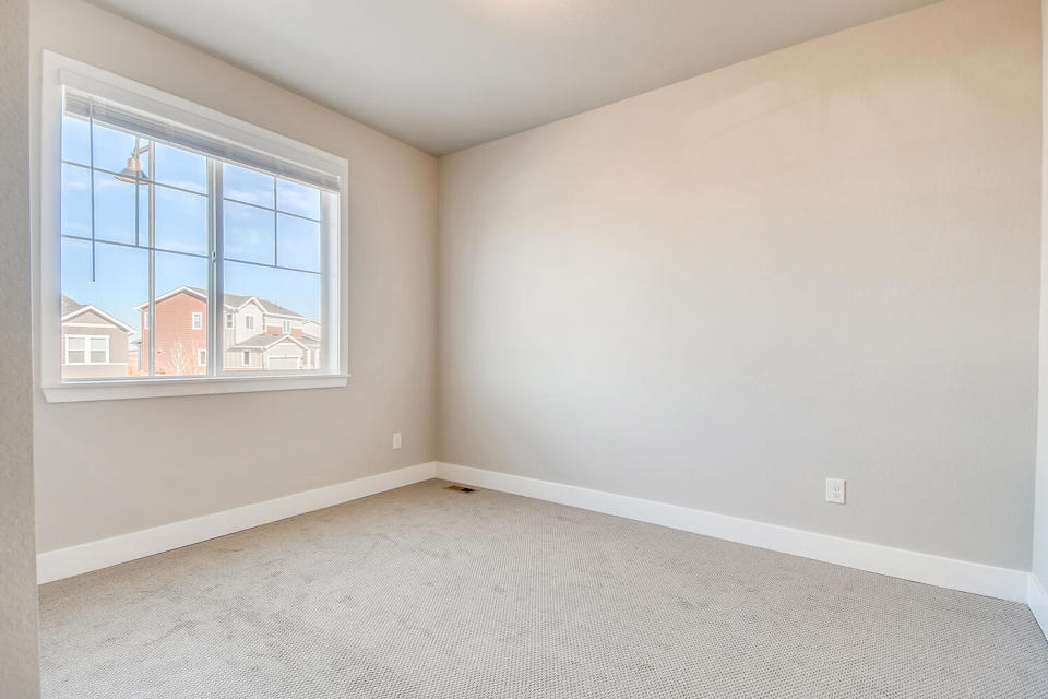 A room with a window and a carpet.