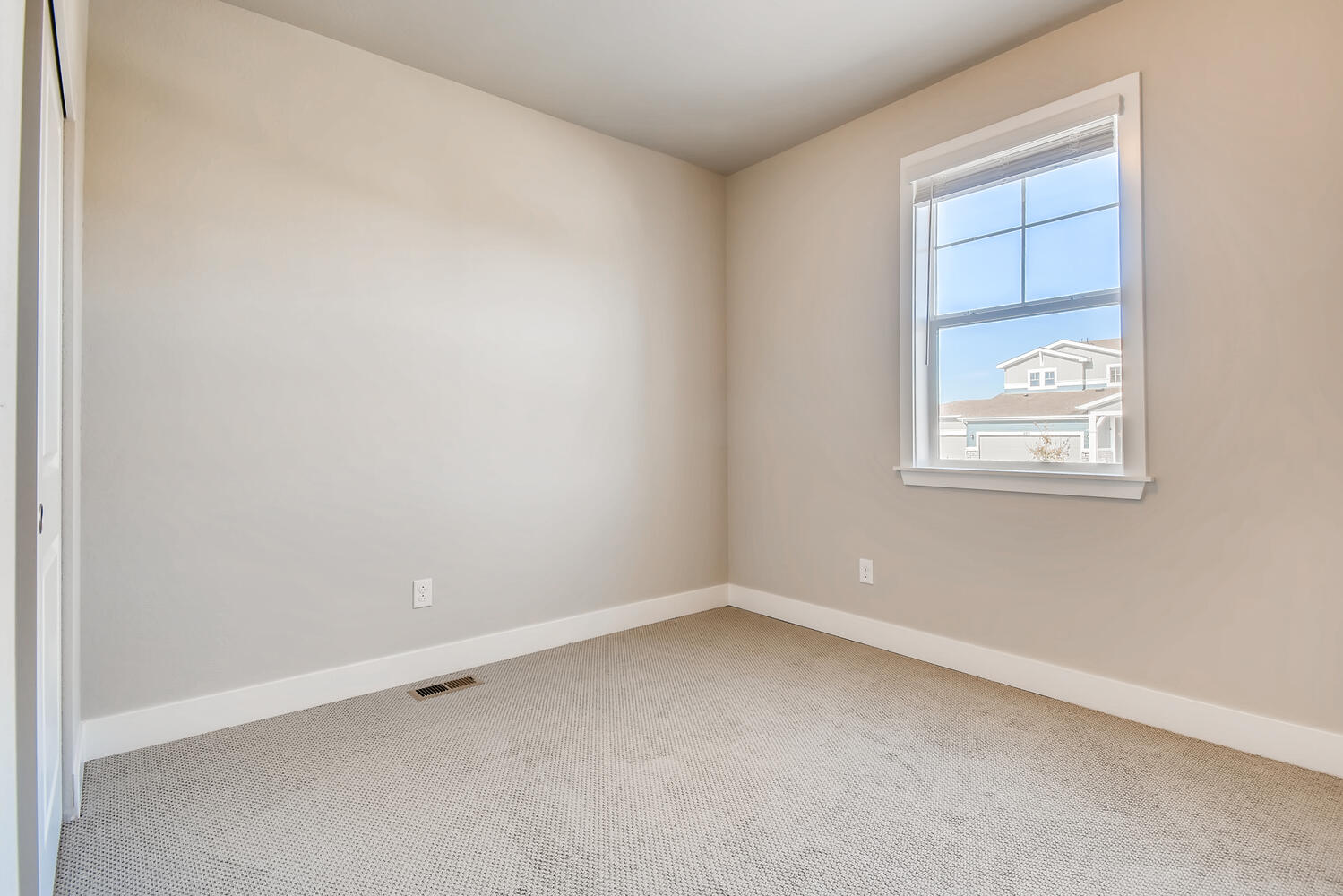 A room with a window and a carpet.