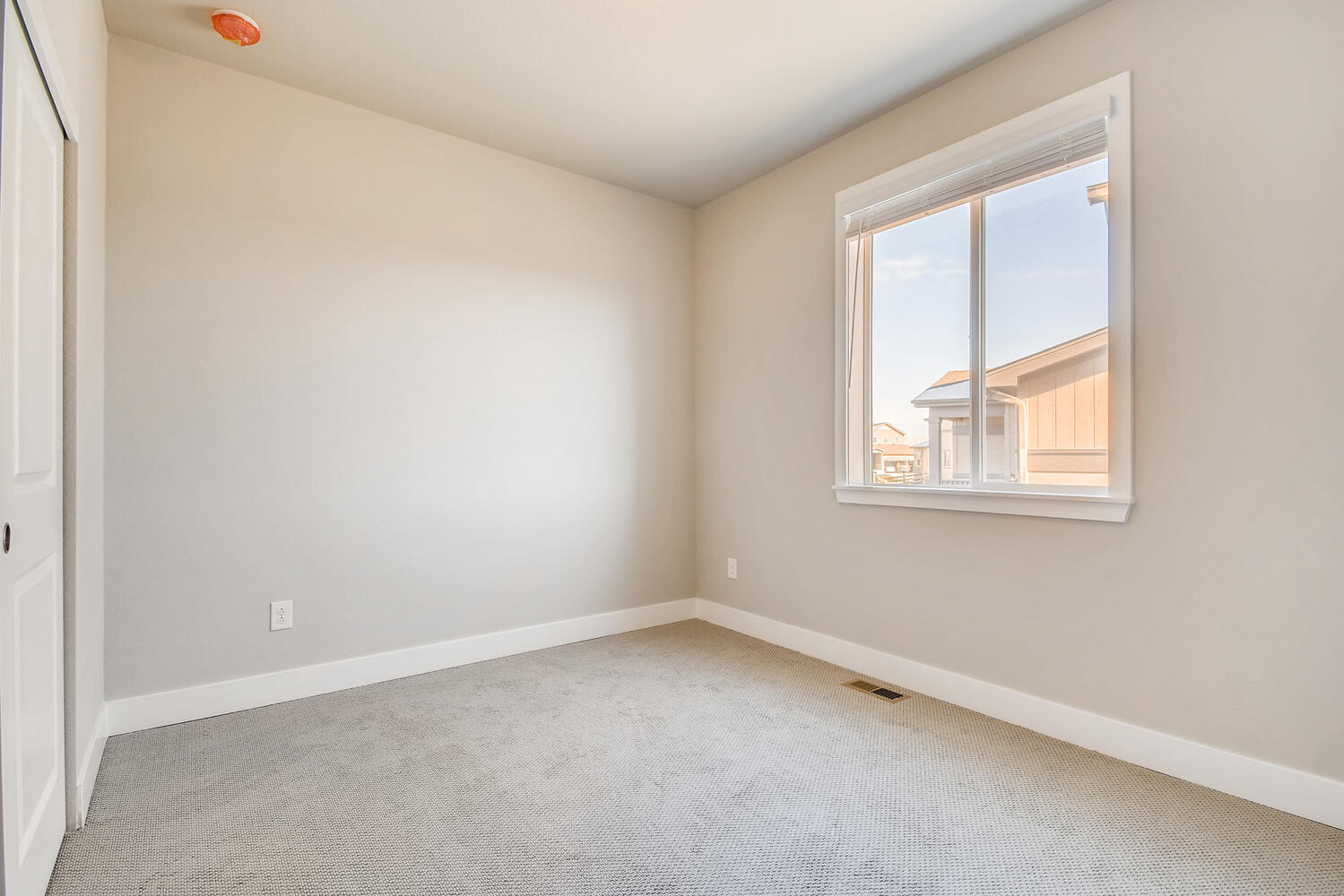 A room with a window and a carpet.