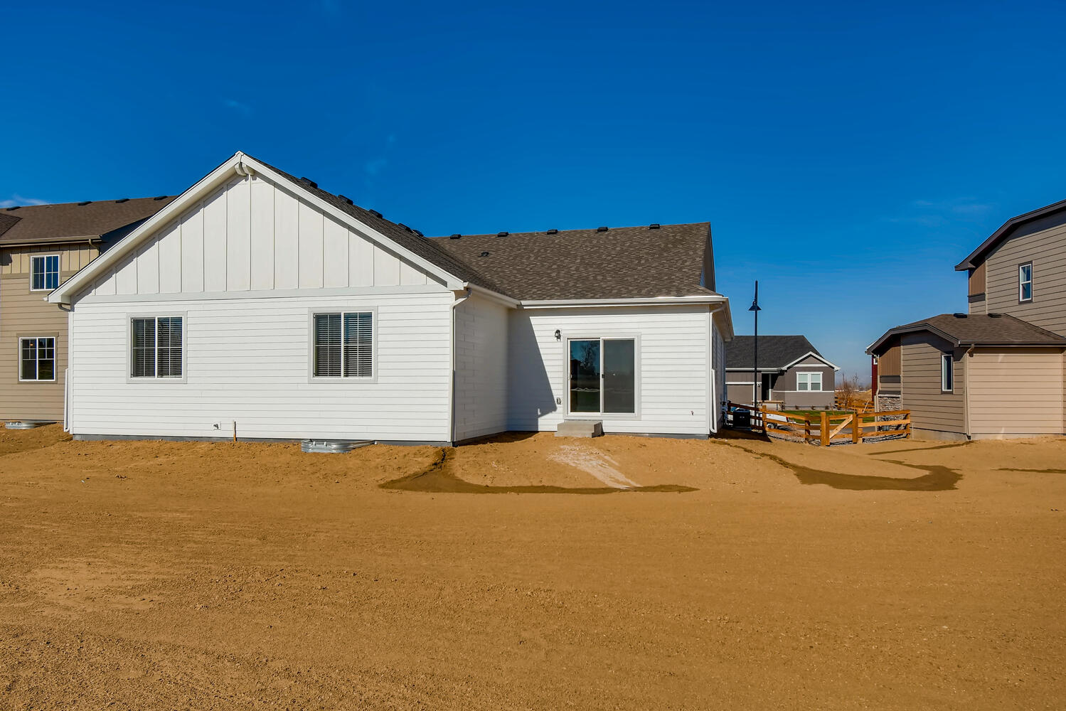 A white house with a dirt yard.