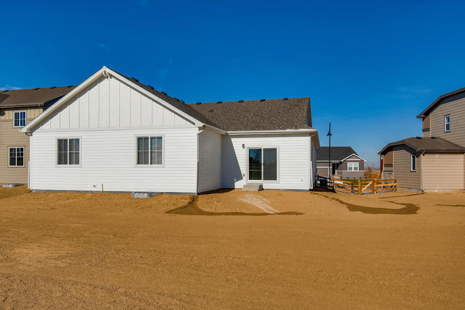 A white house with a dirt yard.
