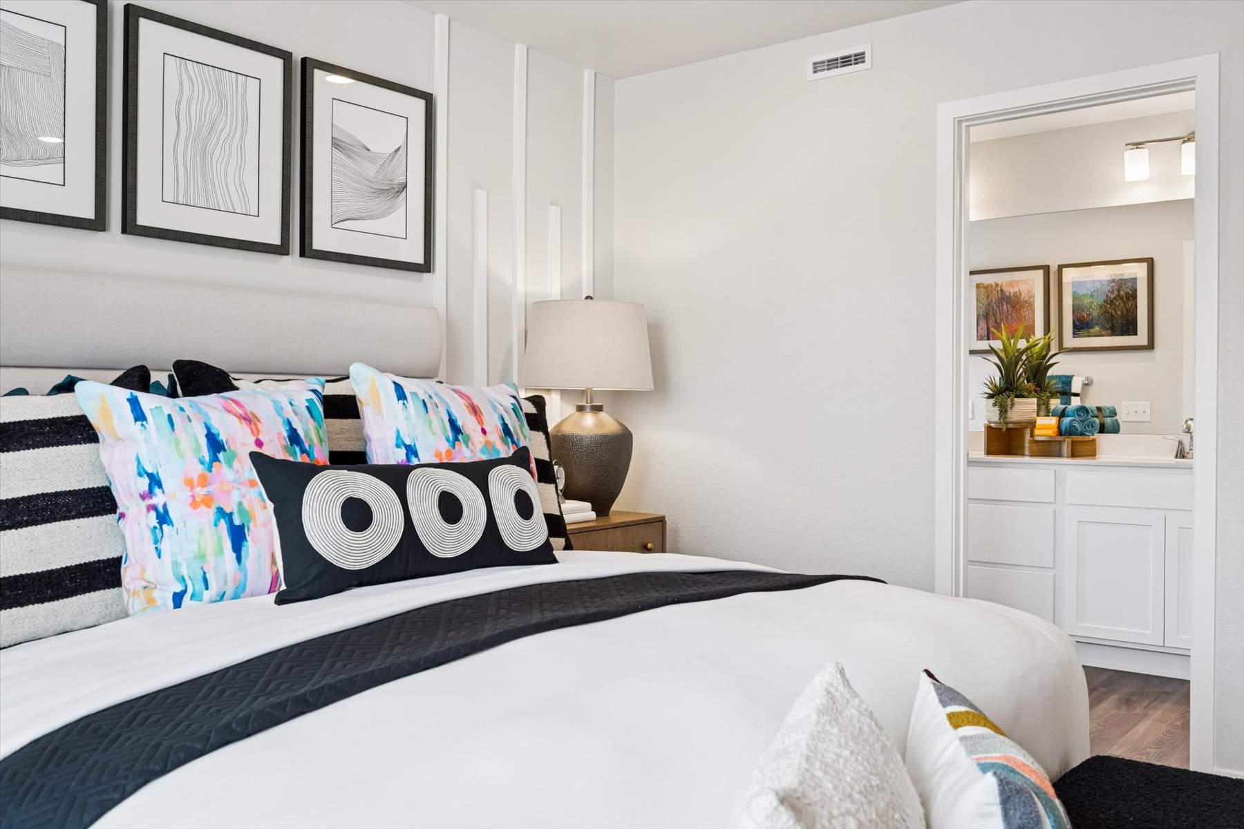 A bed with a white and black comforter.