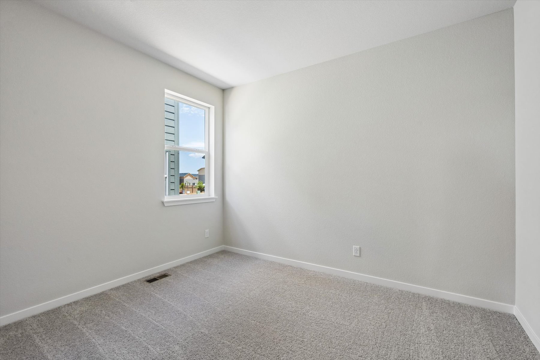 A room with a window and carpet.