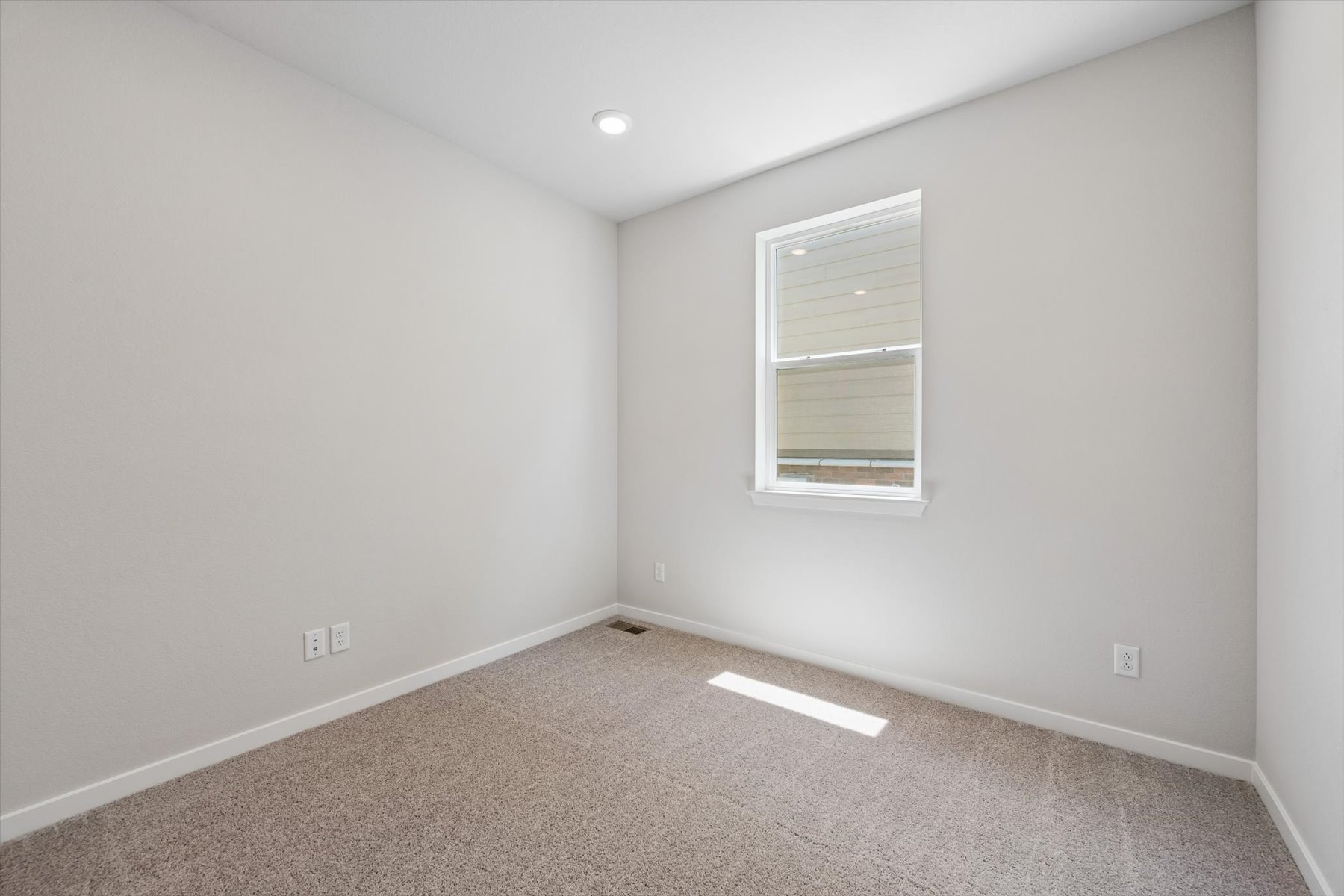 A room with a window and carpet.