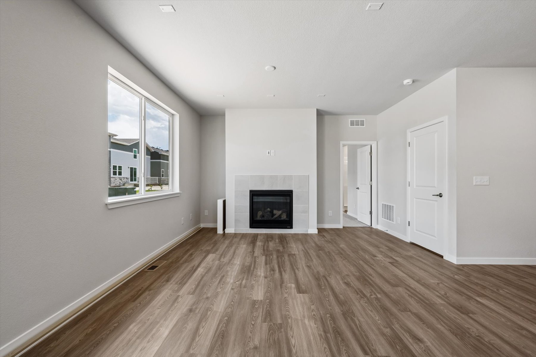 A room with a fireplace and a wood floor.