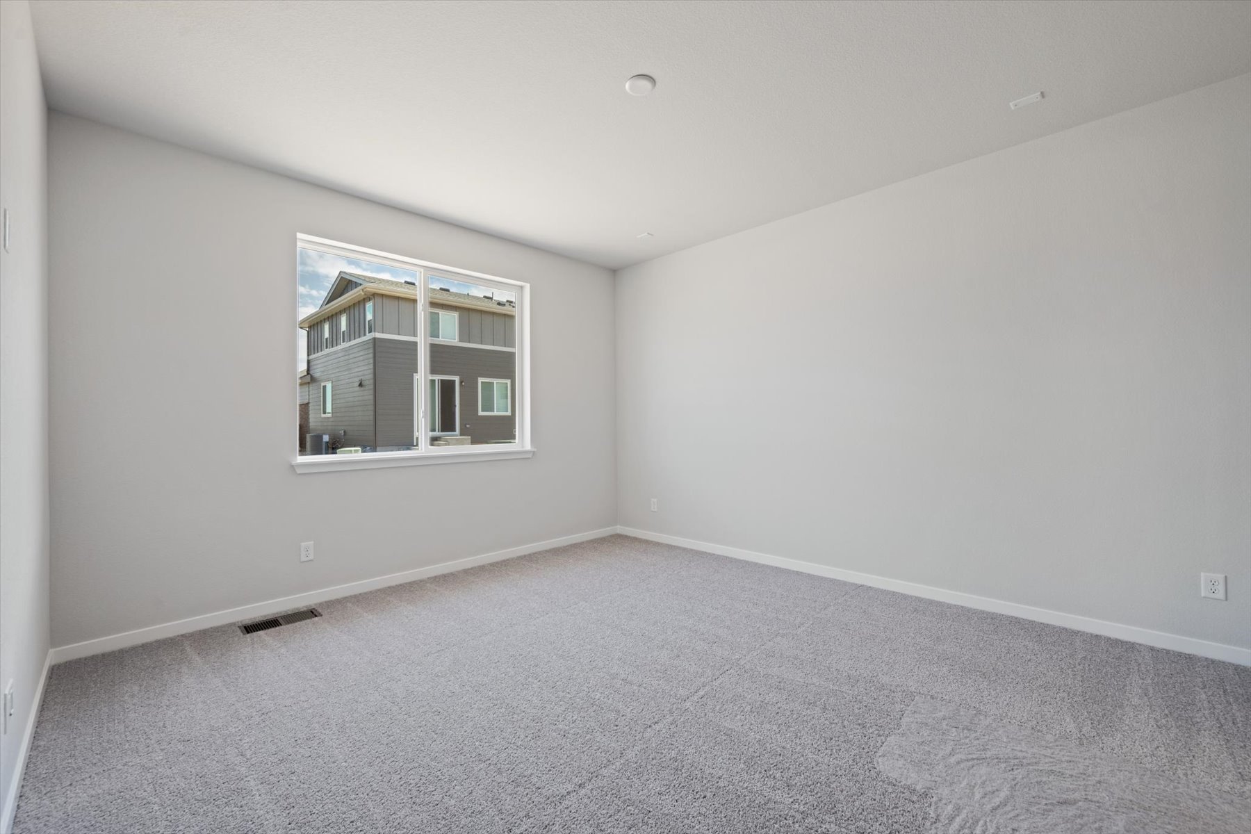 A room with a window and a carpet.
