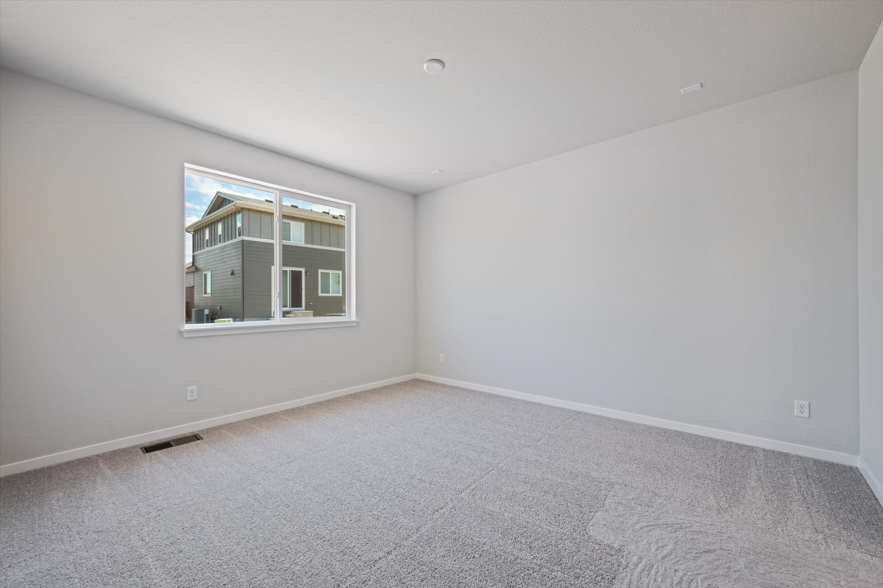 A room with a window and a carpet.