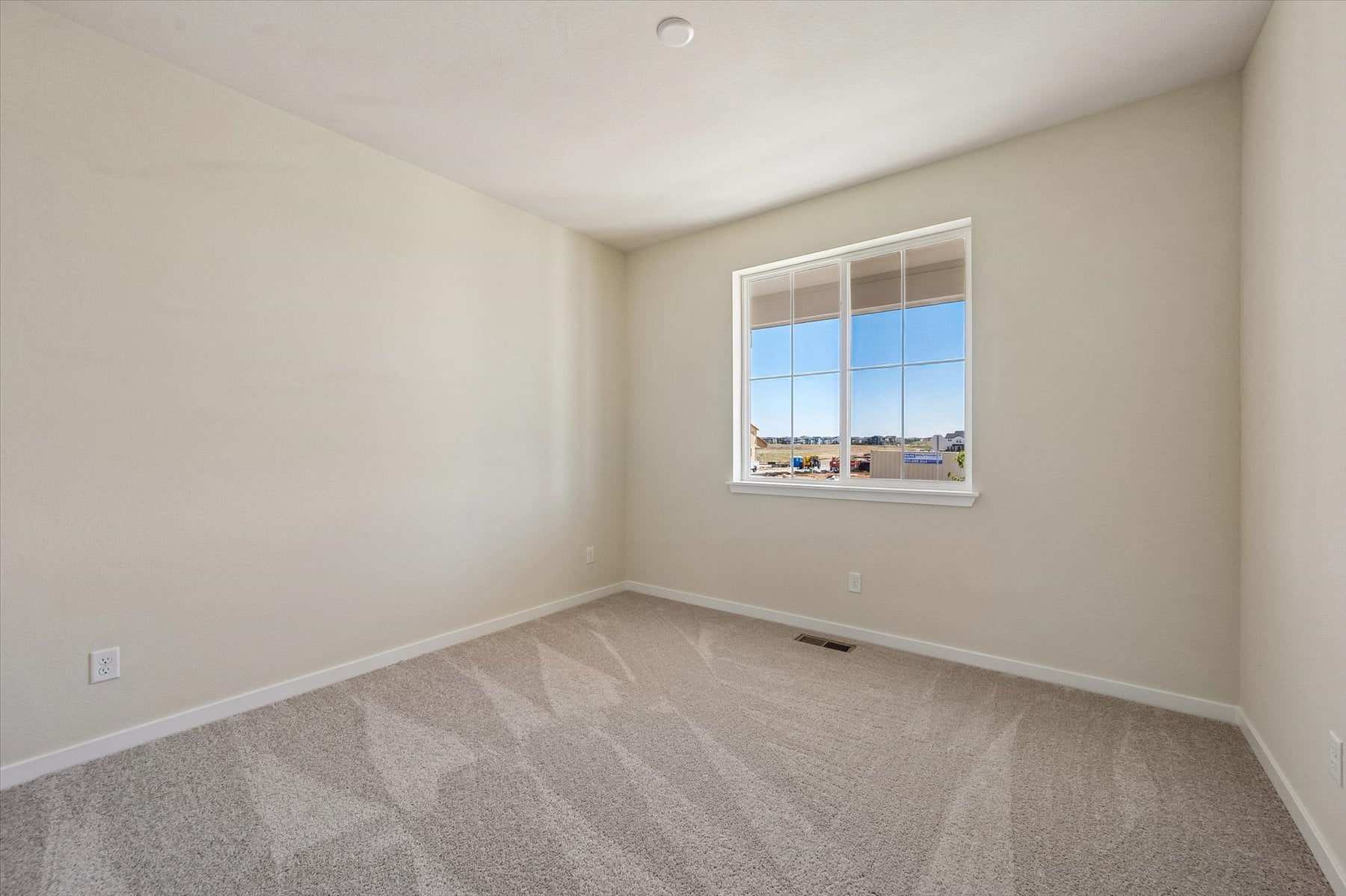 A room with a window and carpet.