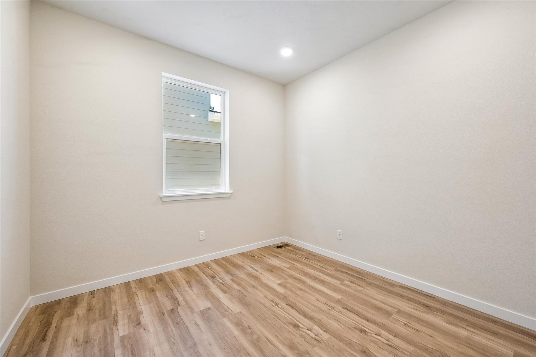 A room with a wood floor and a window.