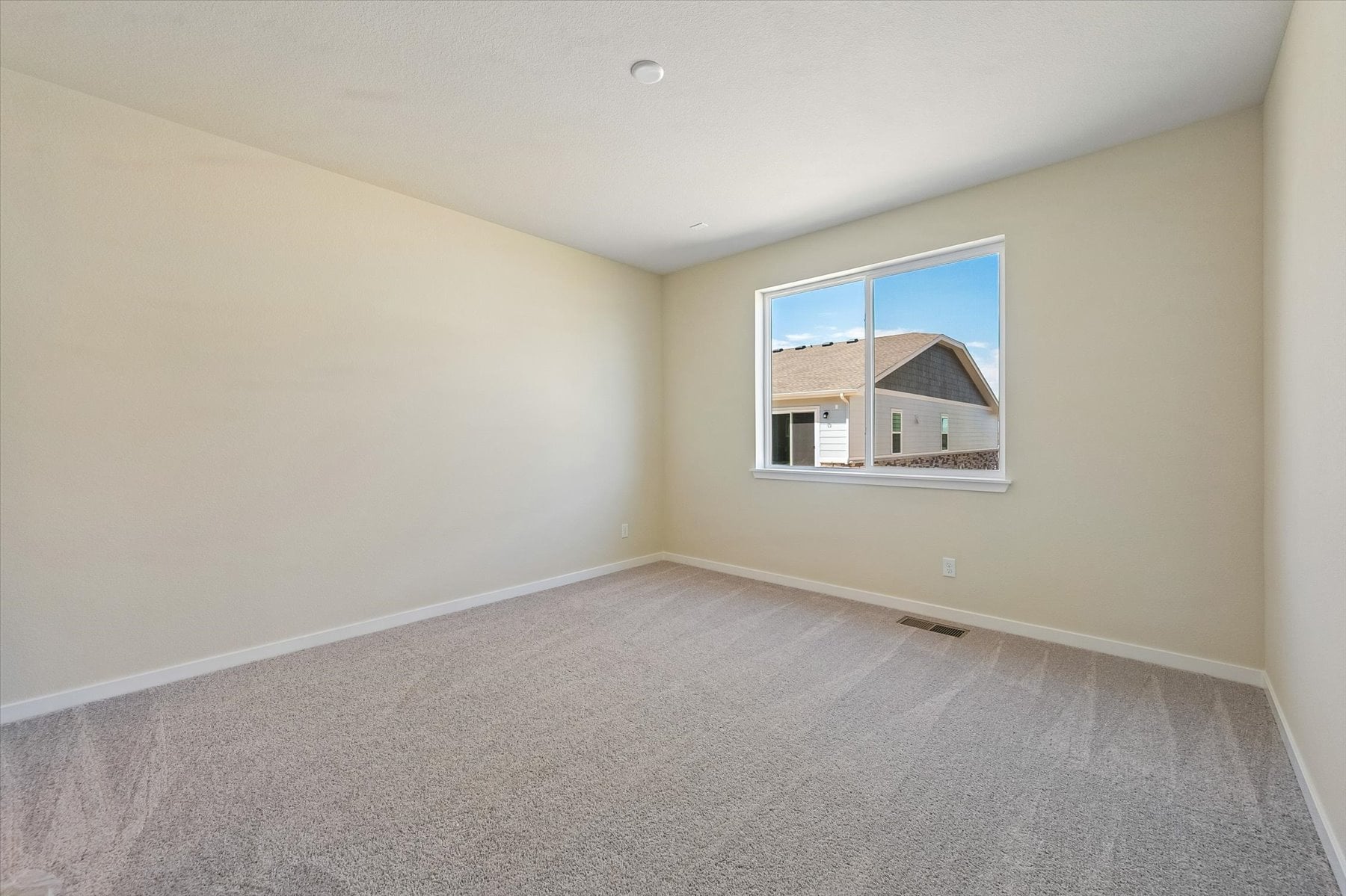 A room with a window and carpet.