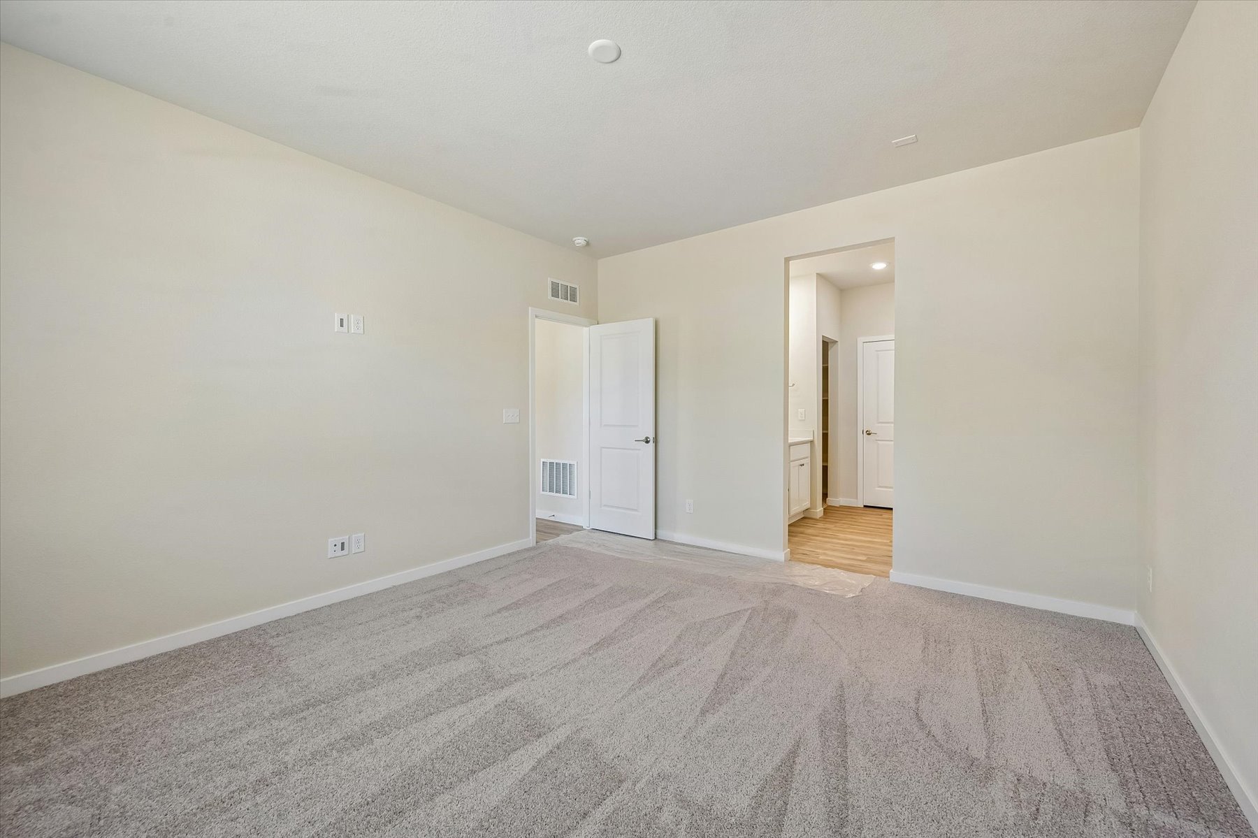 A long hallway with white doors.