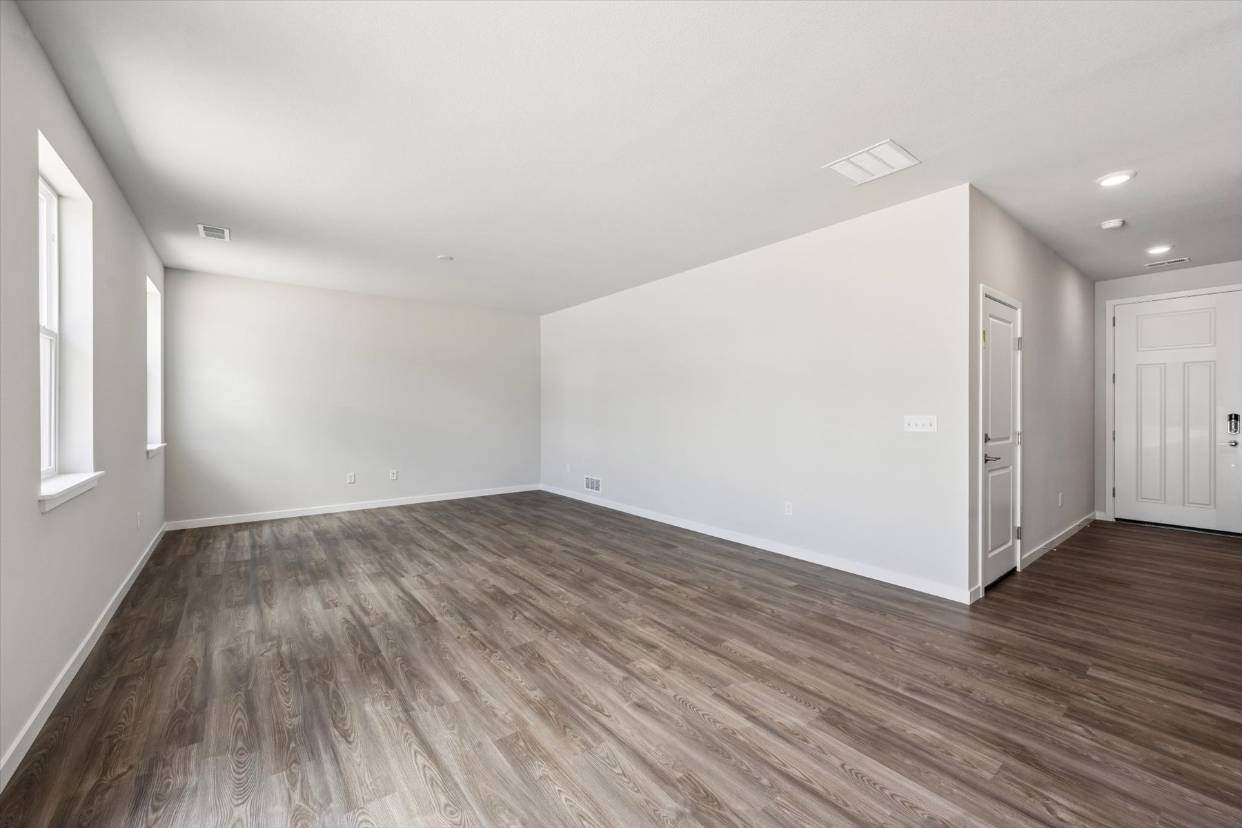 A room with a wood floor and white walls.
