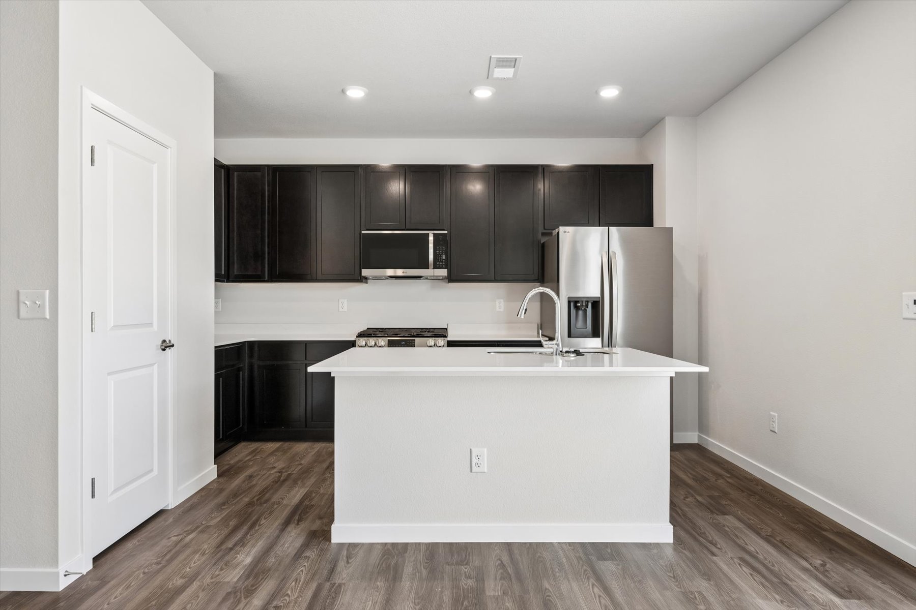 A kitchen with black cabinets.