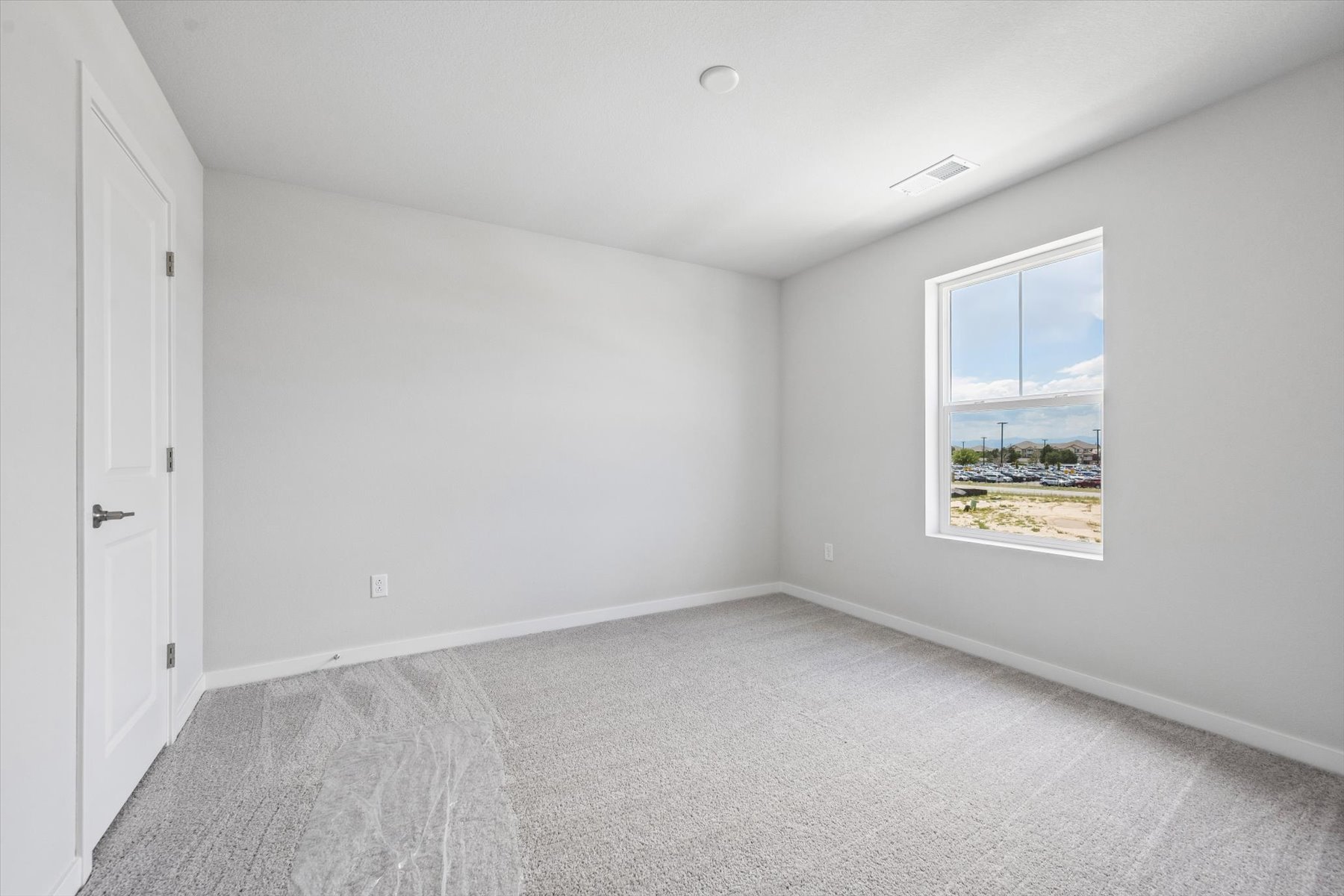 A room with a window and a carpet.