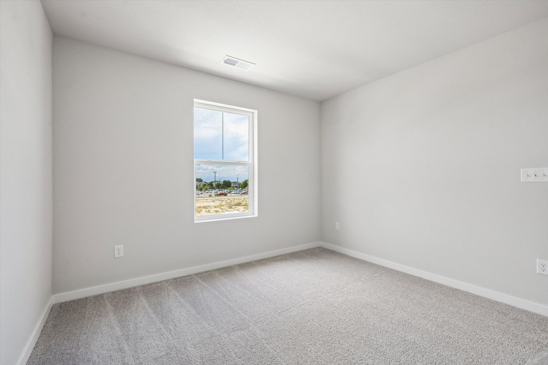 A room with a window and a carpet.