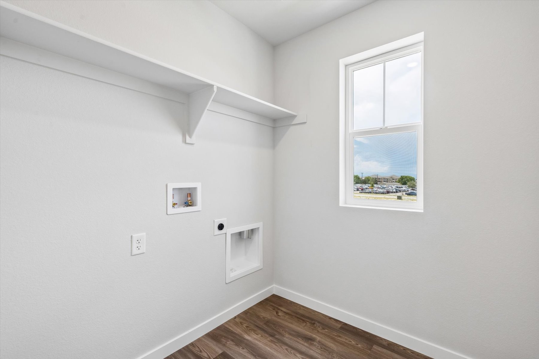 A room with a window and a wood floor.