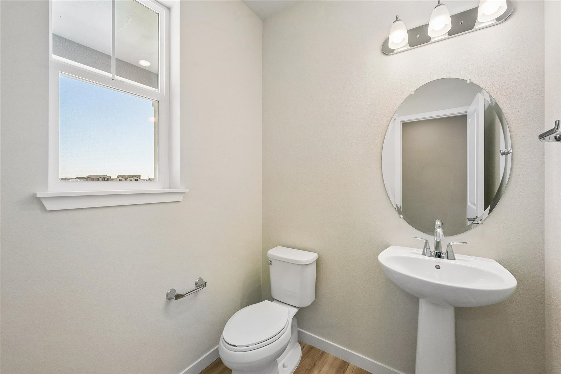 A bathroom with a round mirror.