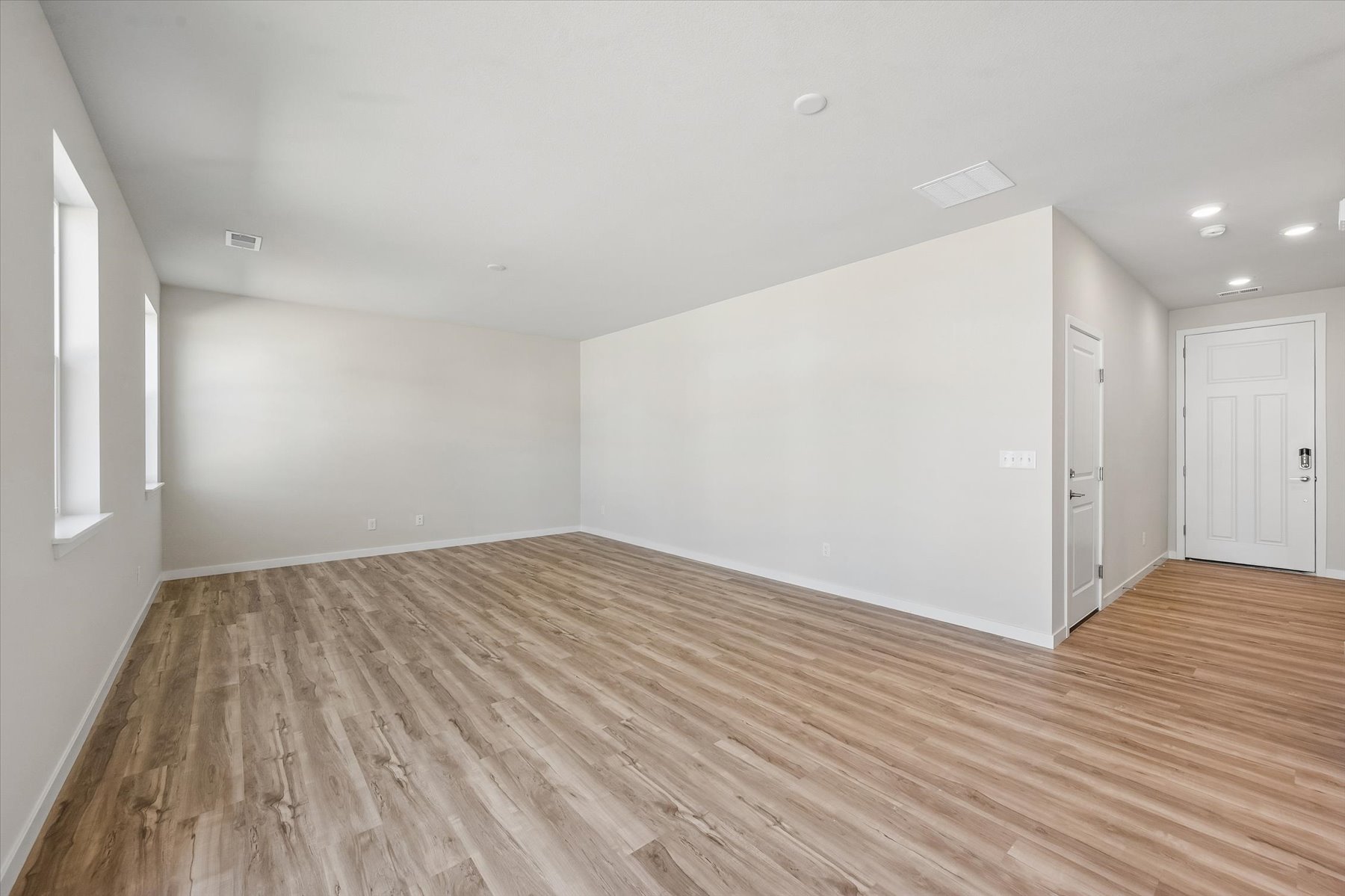 A room with a wood floor and white walls.