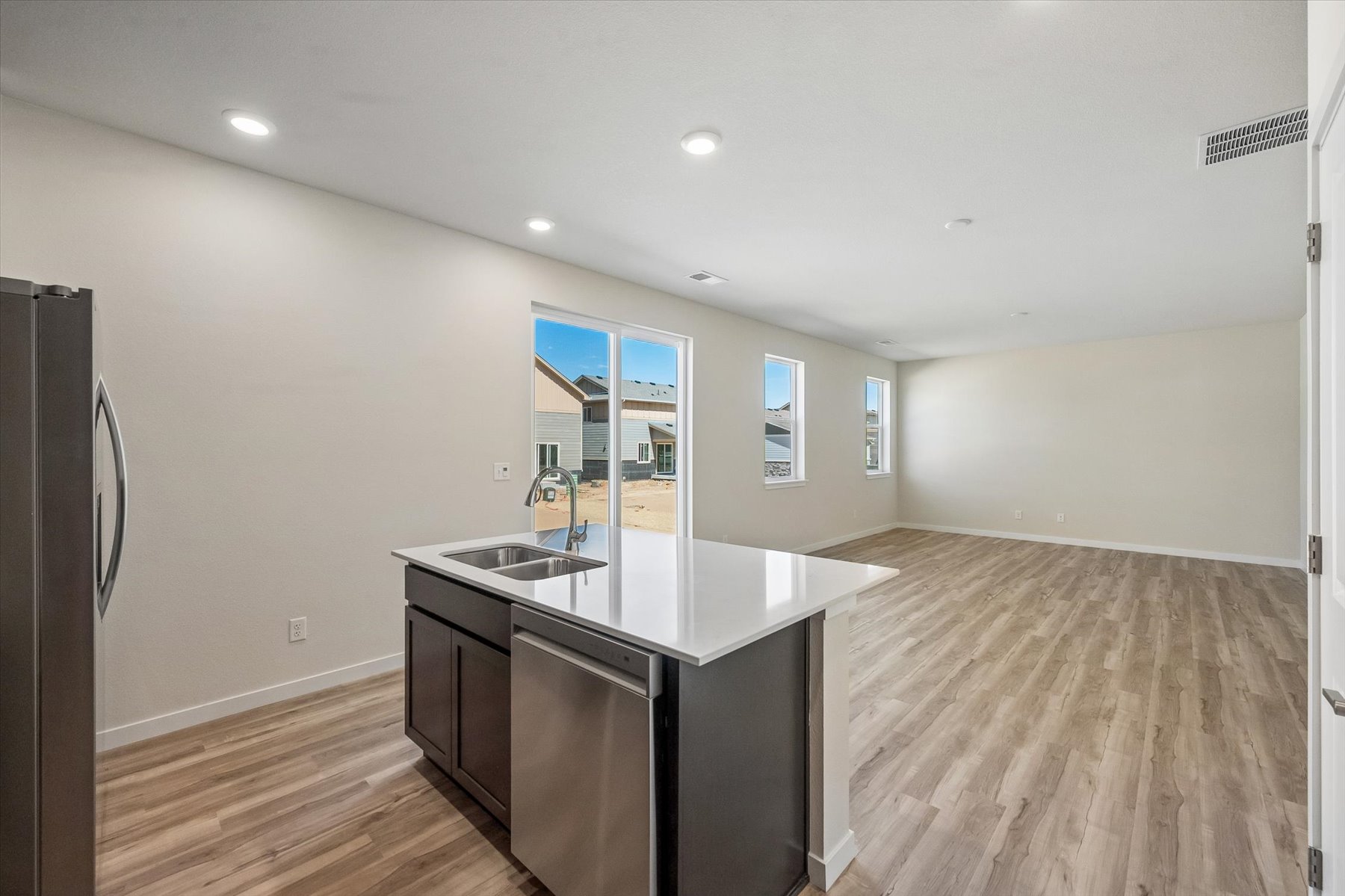 A kitchen with a sink and a refrigerator.