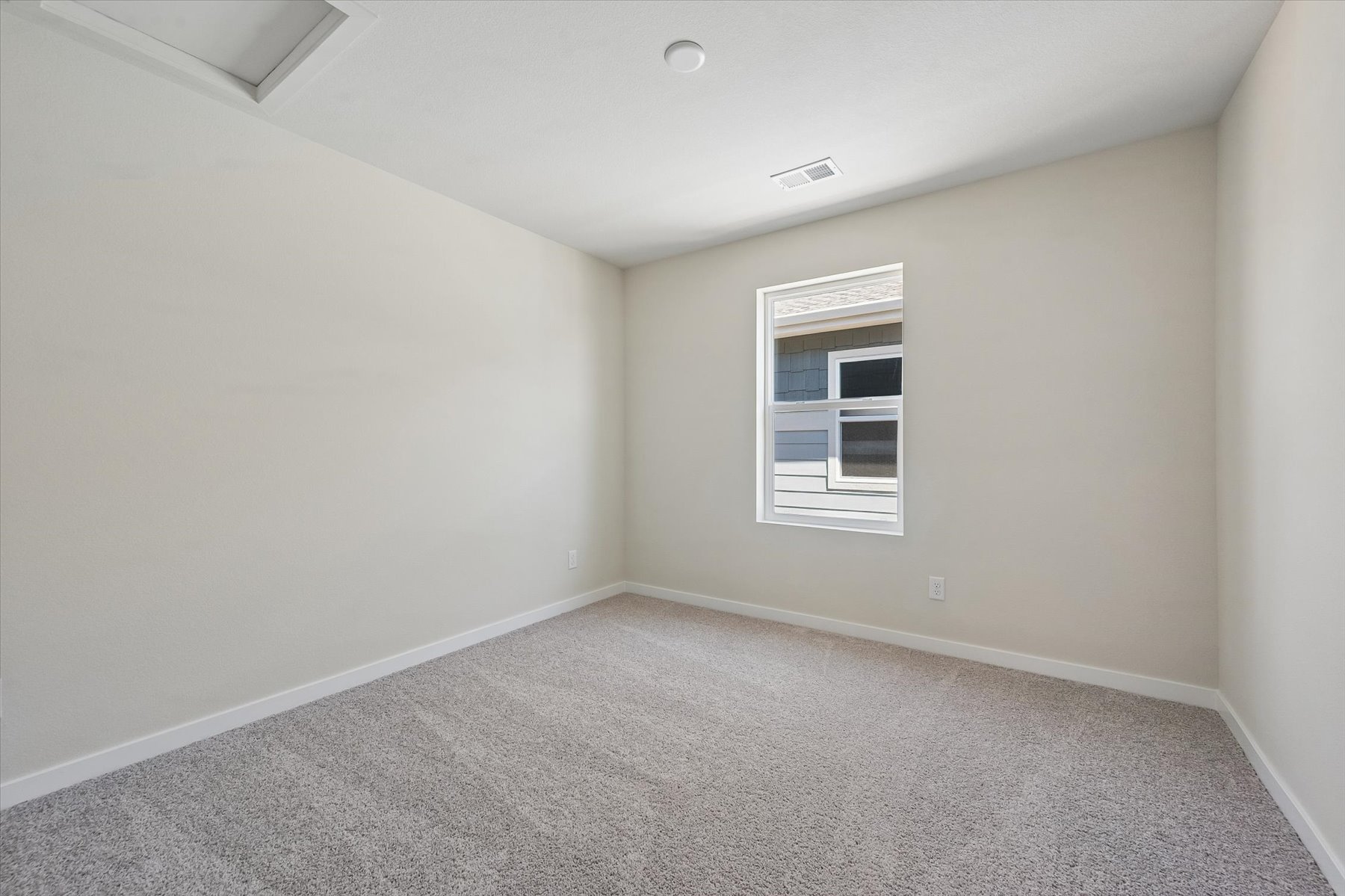 A room with a window and carpet.