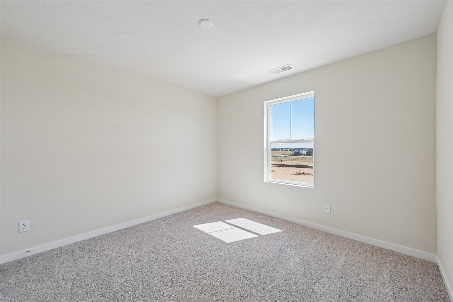 A room with a window and a carpet.