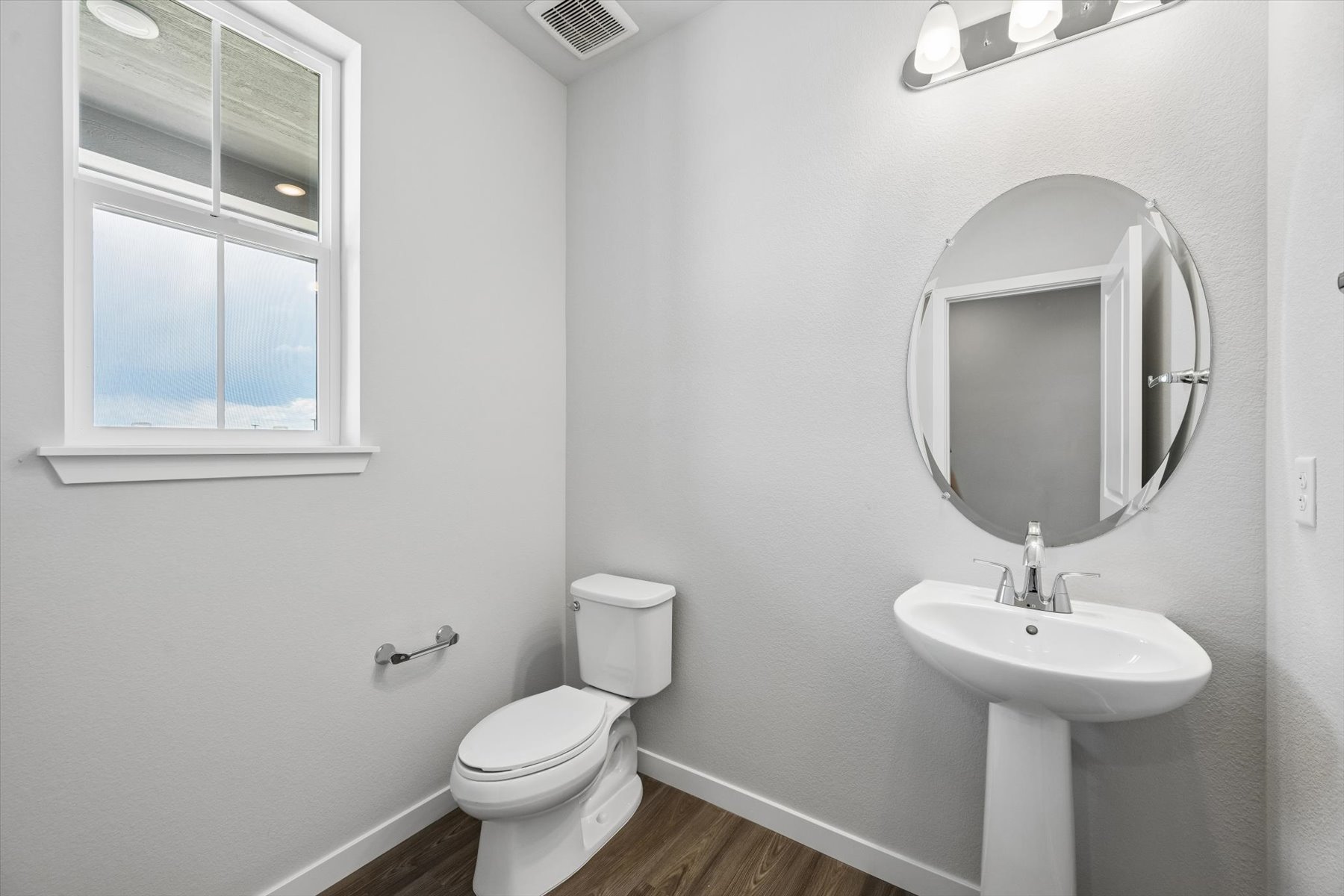 A bathroom with a round mirror.
