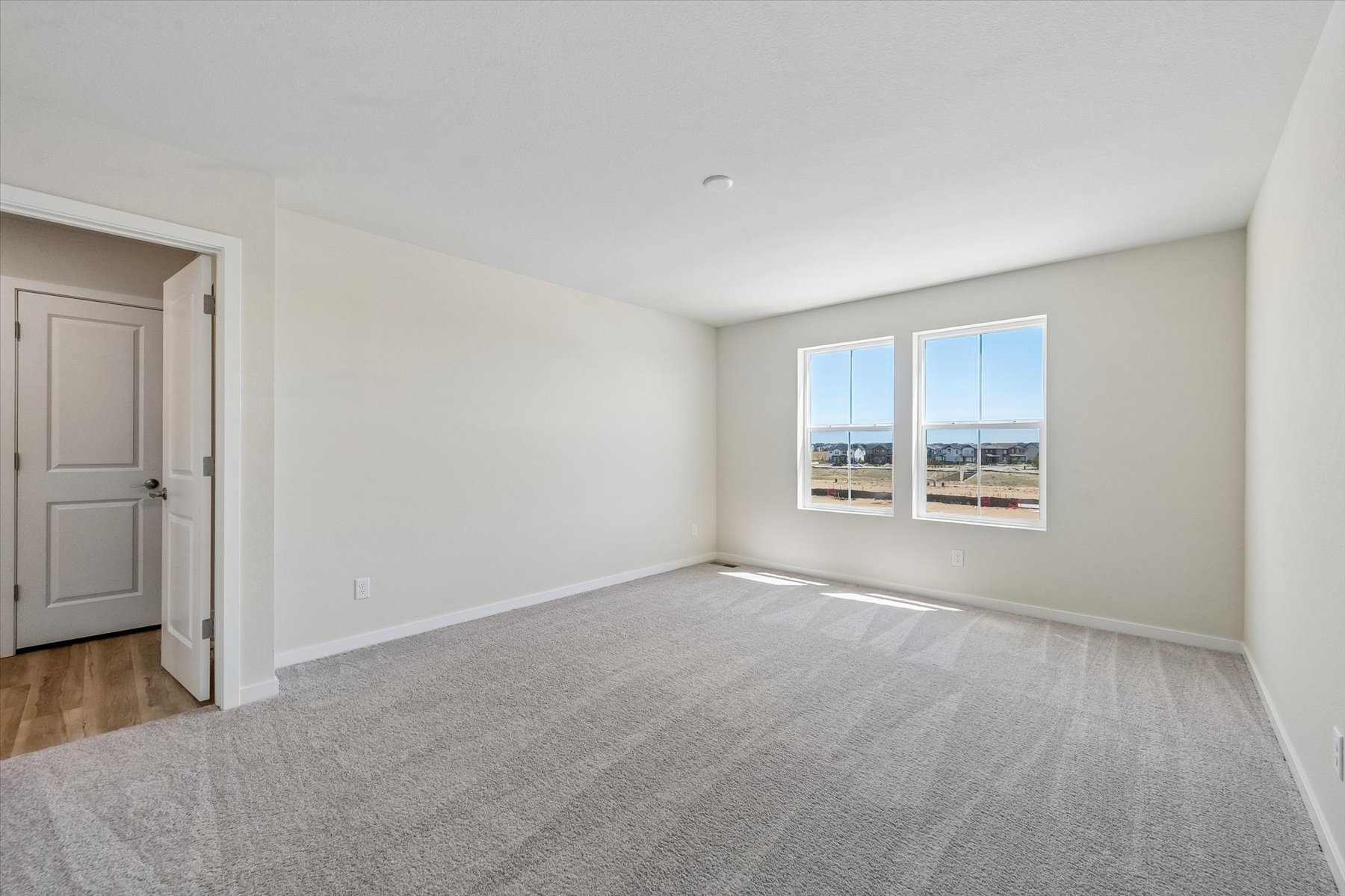 A room with a white wall and a window.