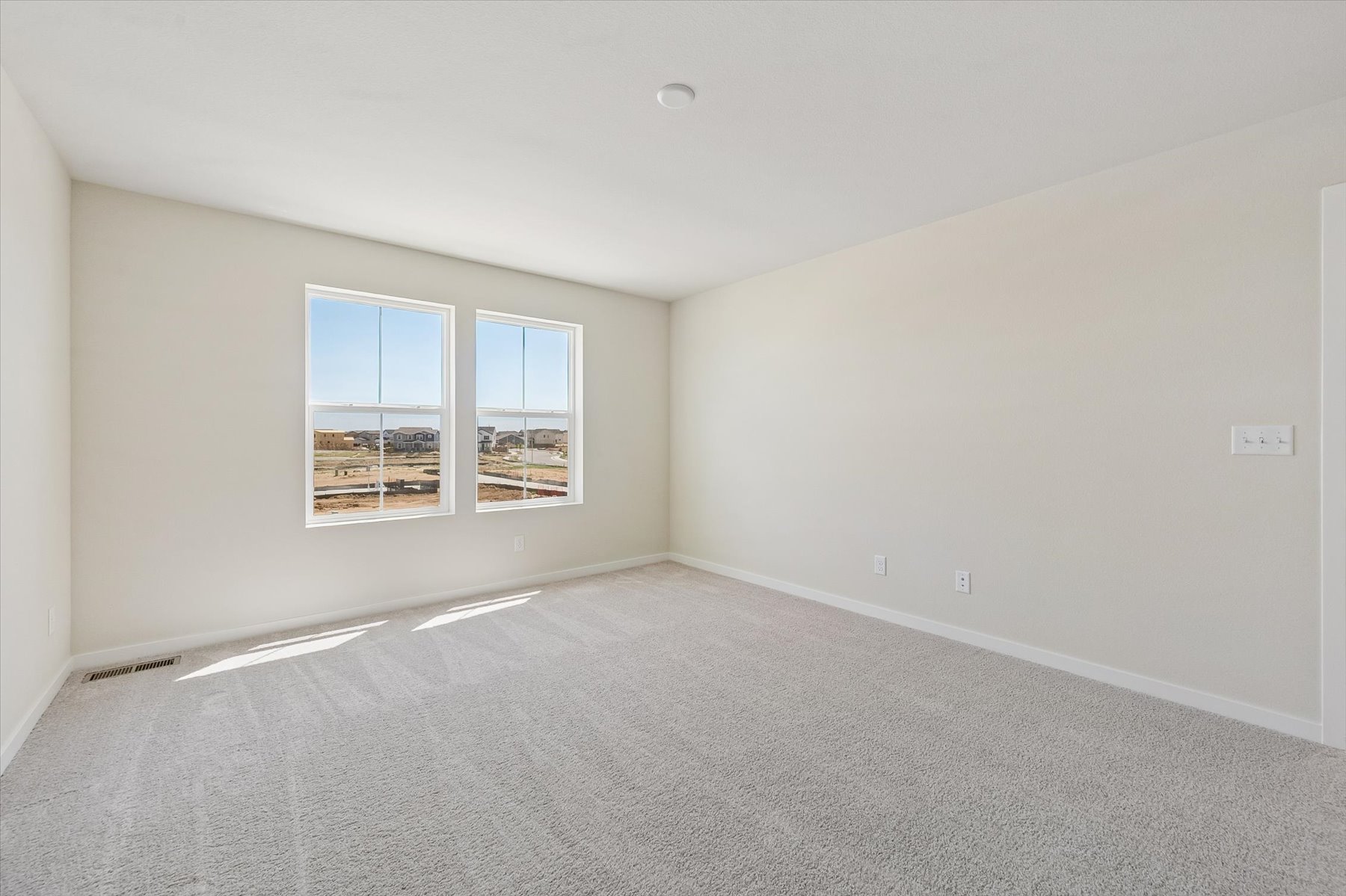 A room with a window and a carpet.