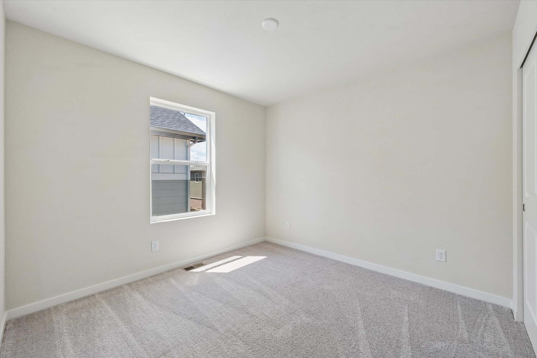 A room with a window and a carpet.