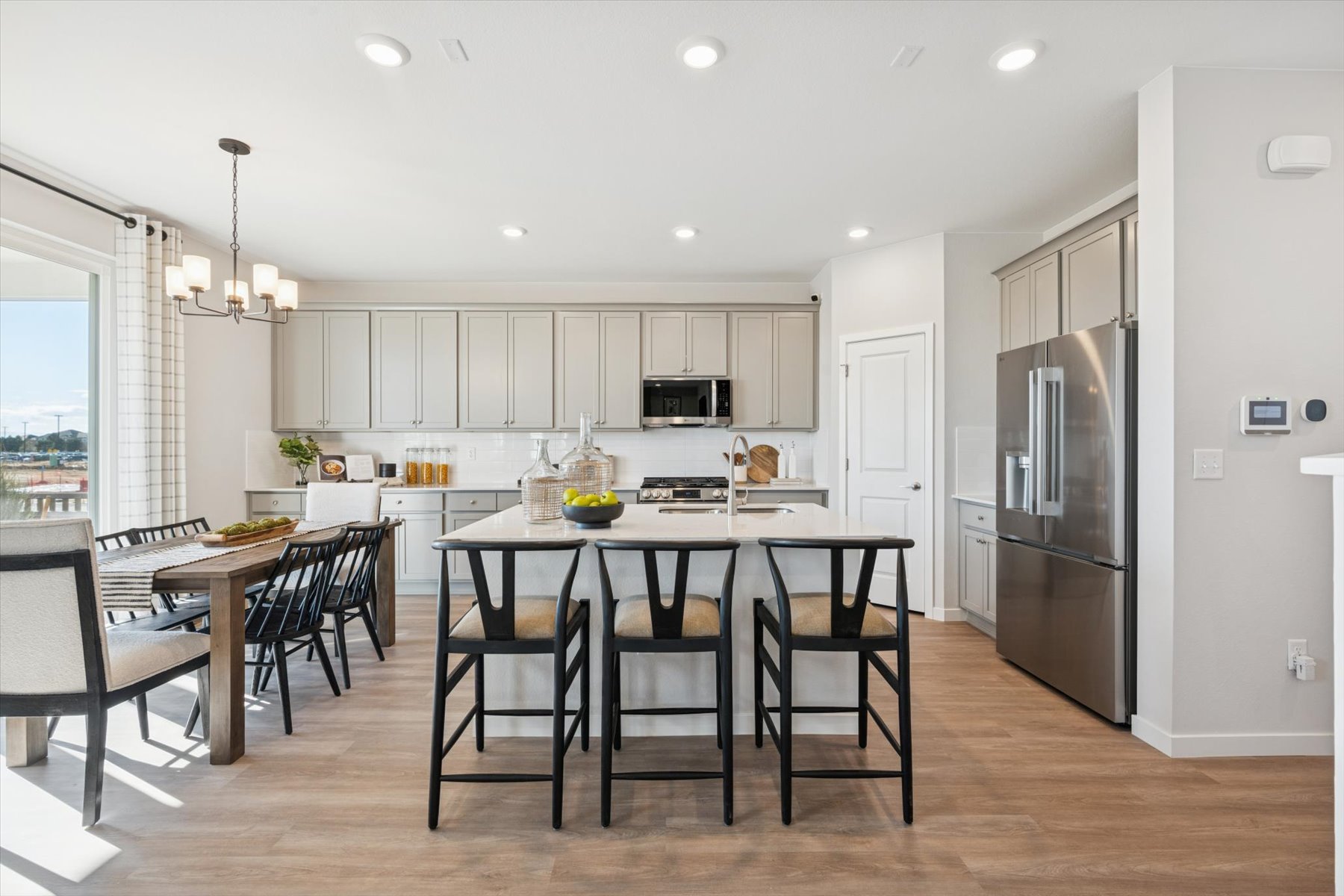A kitchen with a dining table and chairs.