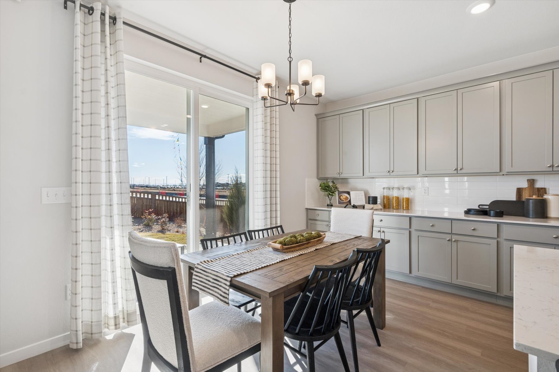 A kitchen with a dining table and chairs.