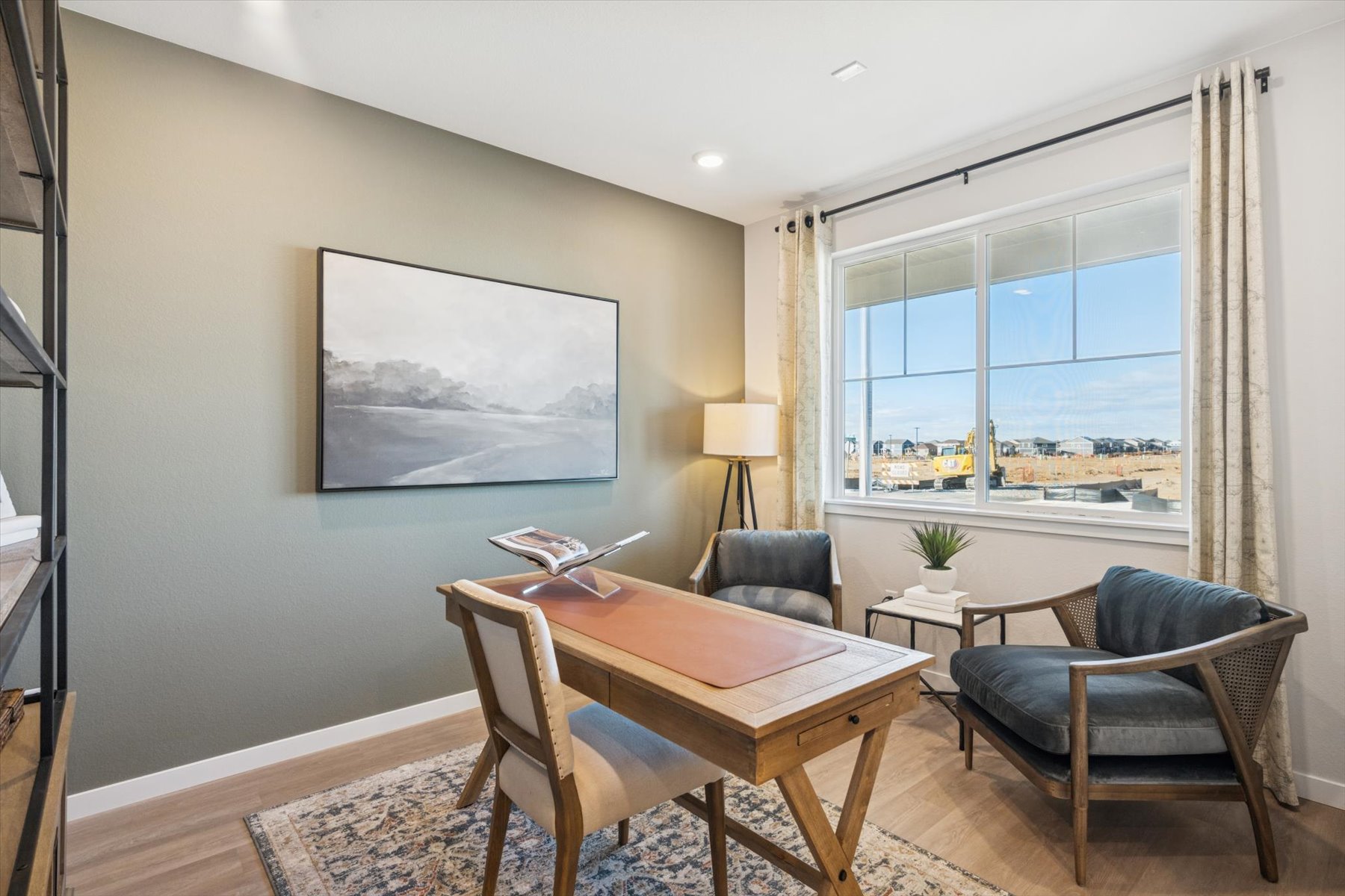 A room with a table chairs and a window with a view of the city.