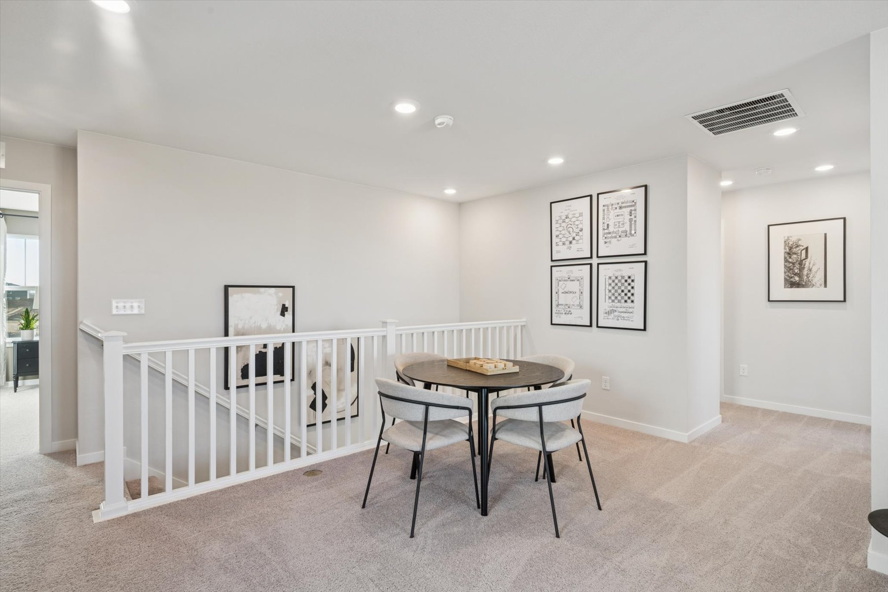 A dining room with a white table and chairs.