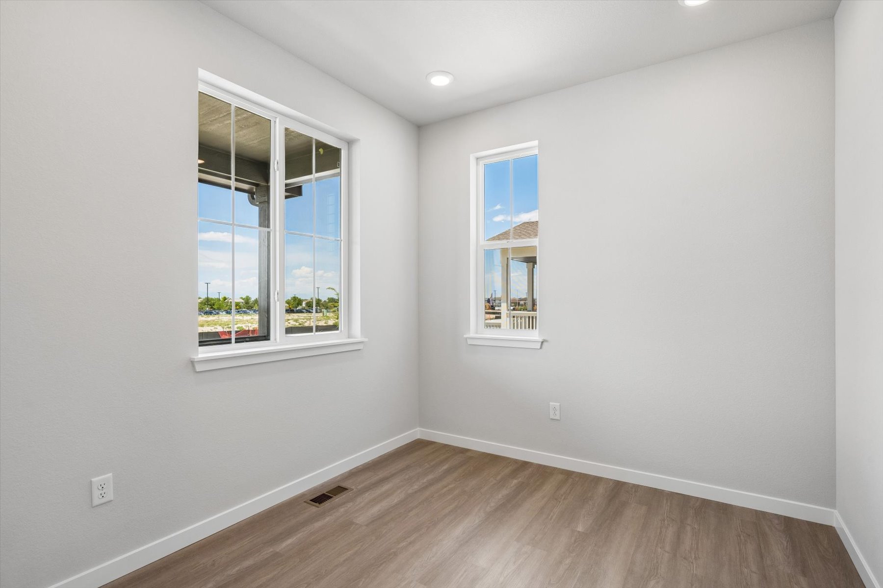 A room with windows and a wood floor.