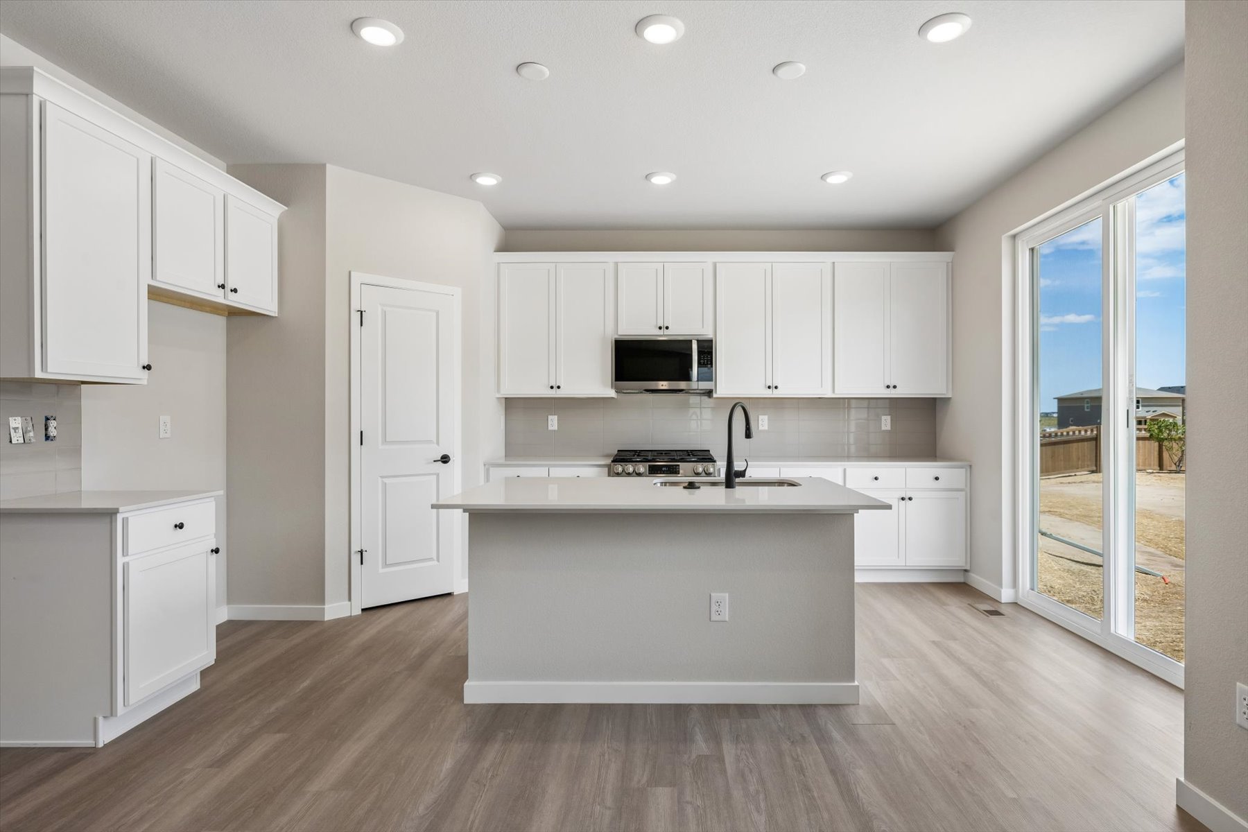 A kitchen with white cabinets.